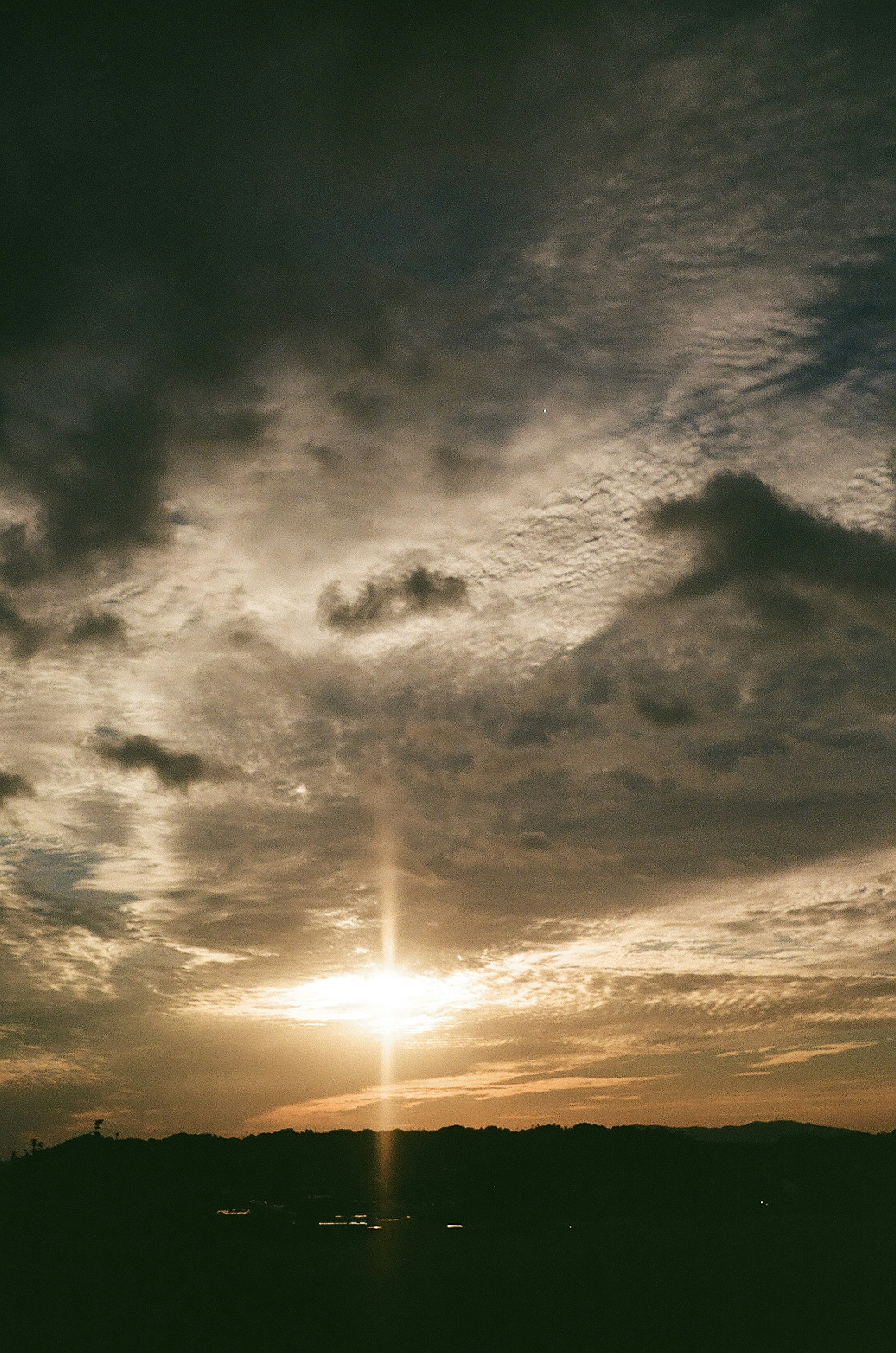 Paesaggio mozzafiato con raggi di sole al tramonto che penetrano tra le nuvole