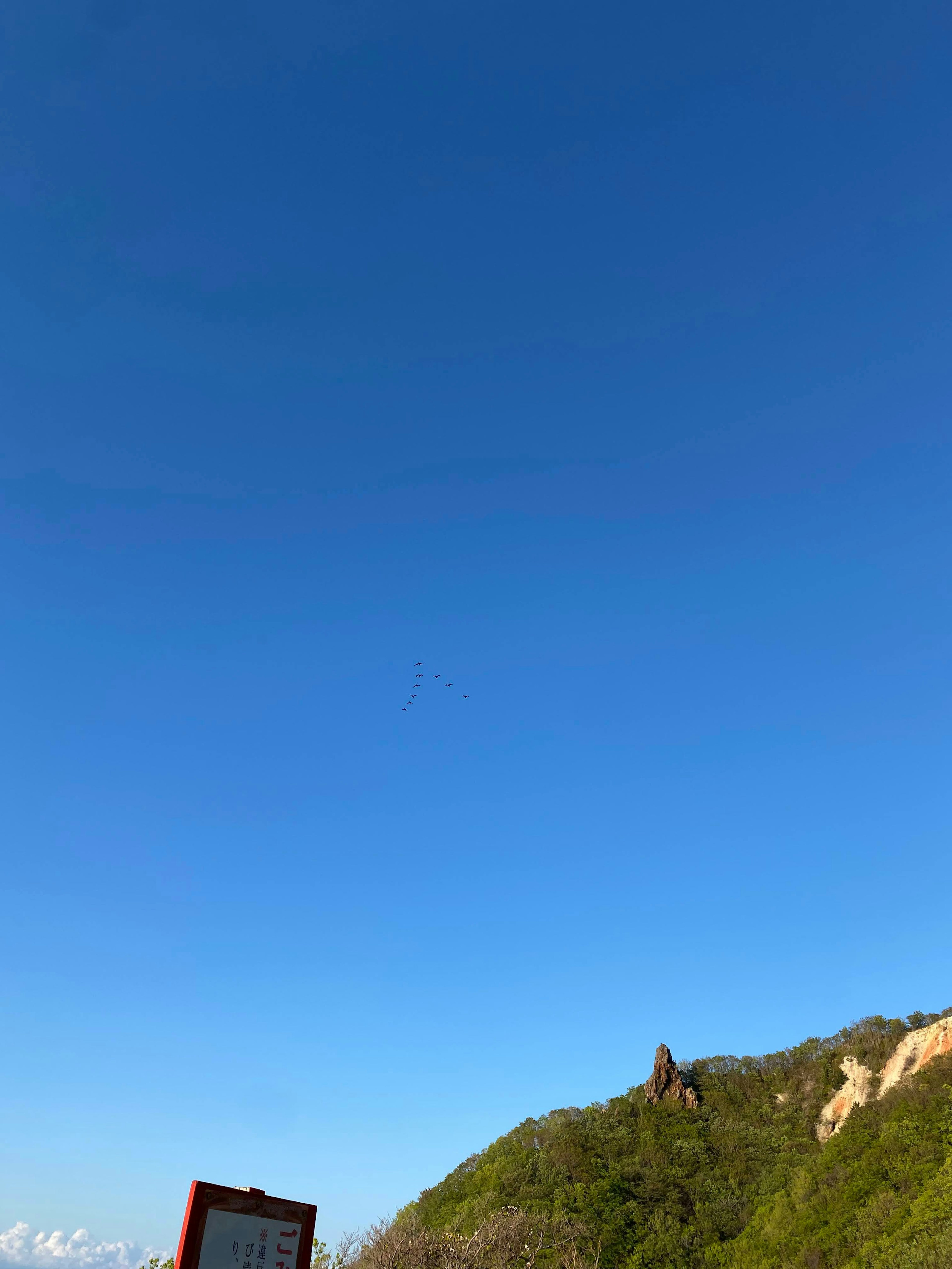 Clear blue sky with green hillside