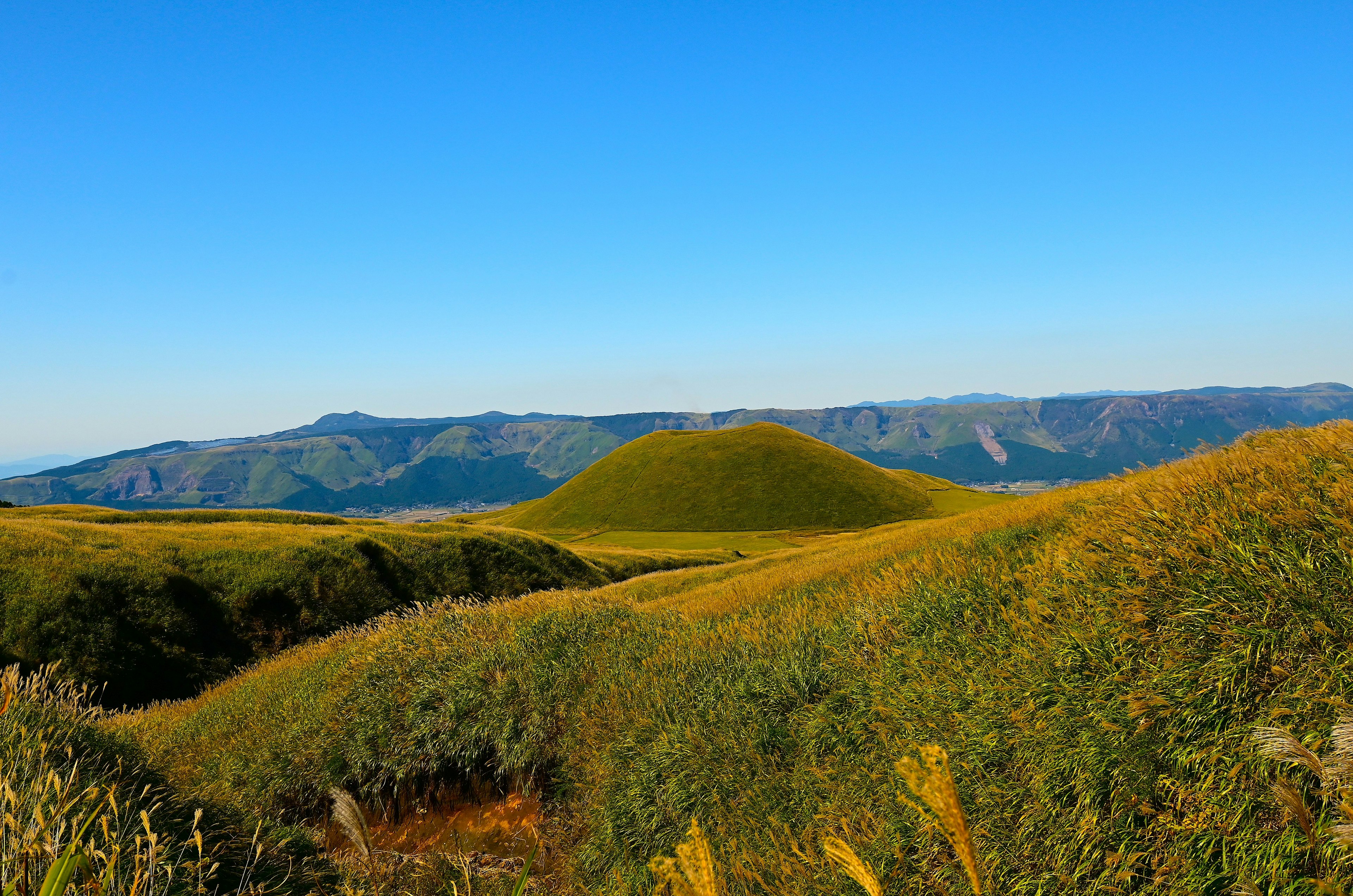 Paisaje de colinas verdes y pradera bajo un cielo azul