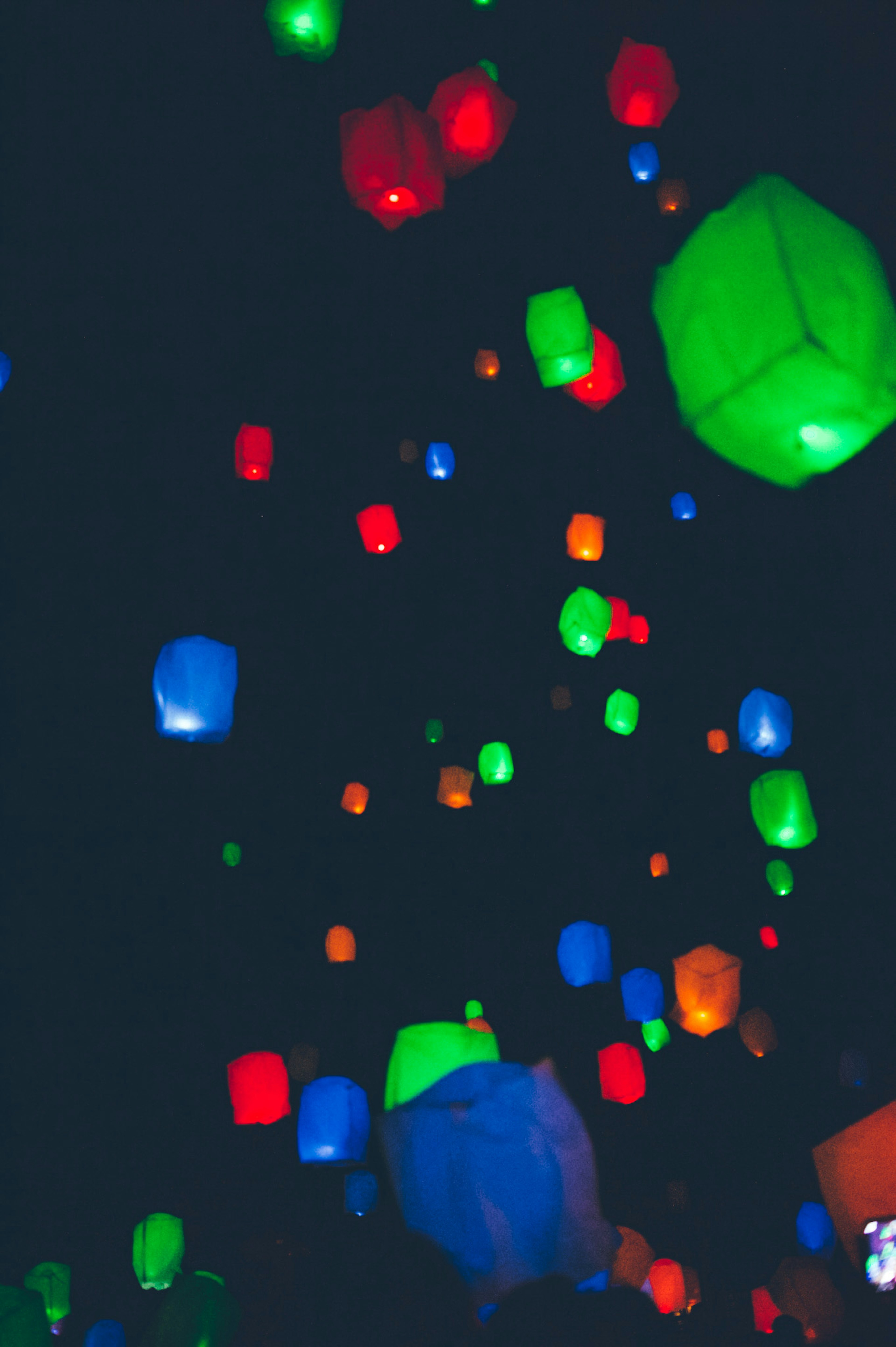 Linternas coloridas flotando en el cielo nocturno creando una atmósfera mágica