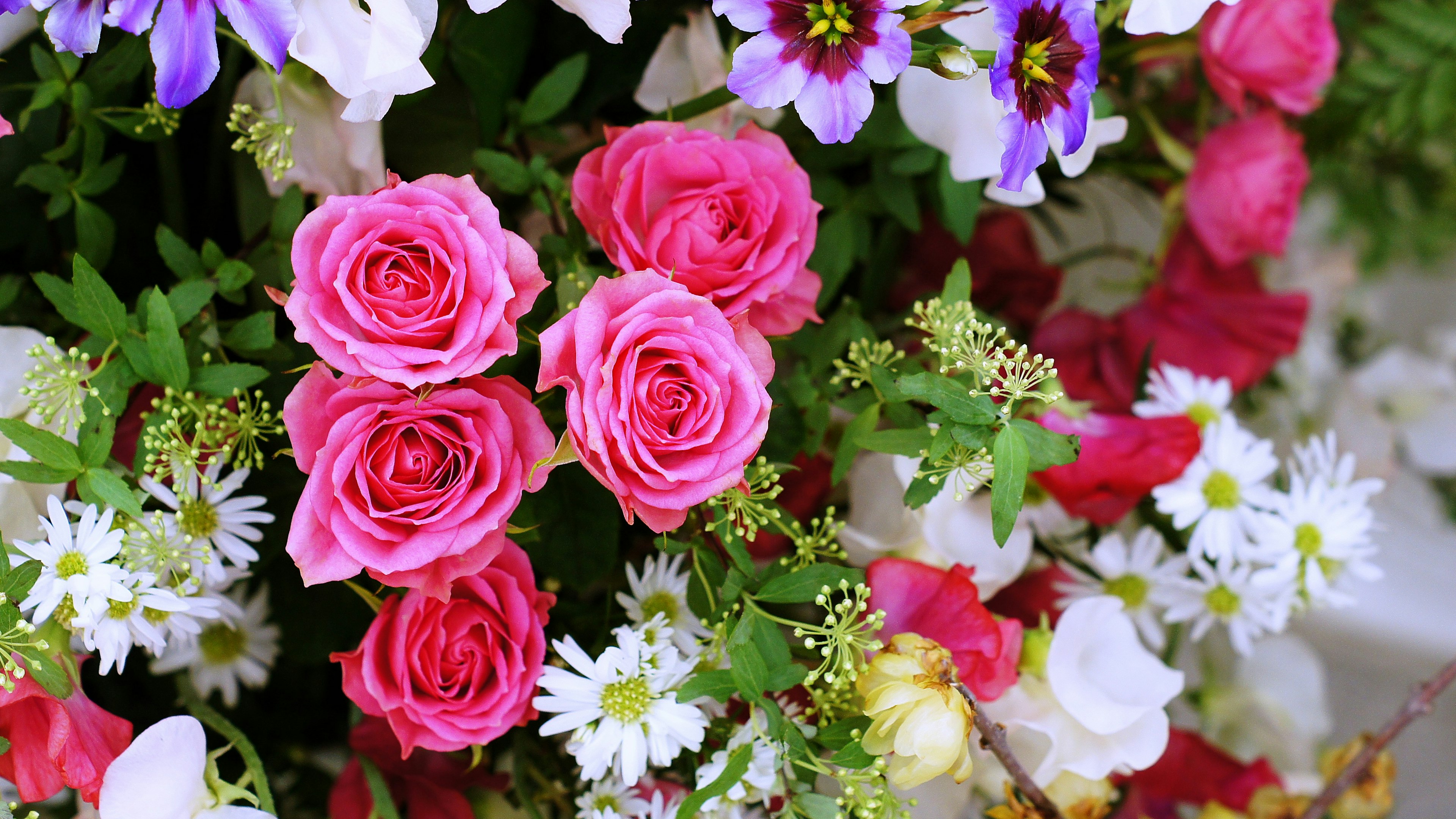 Composizione floreale vivace con rose rosa in evidenza