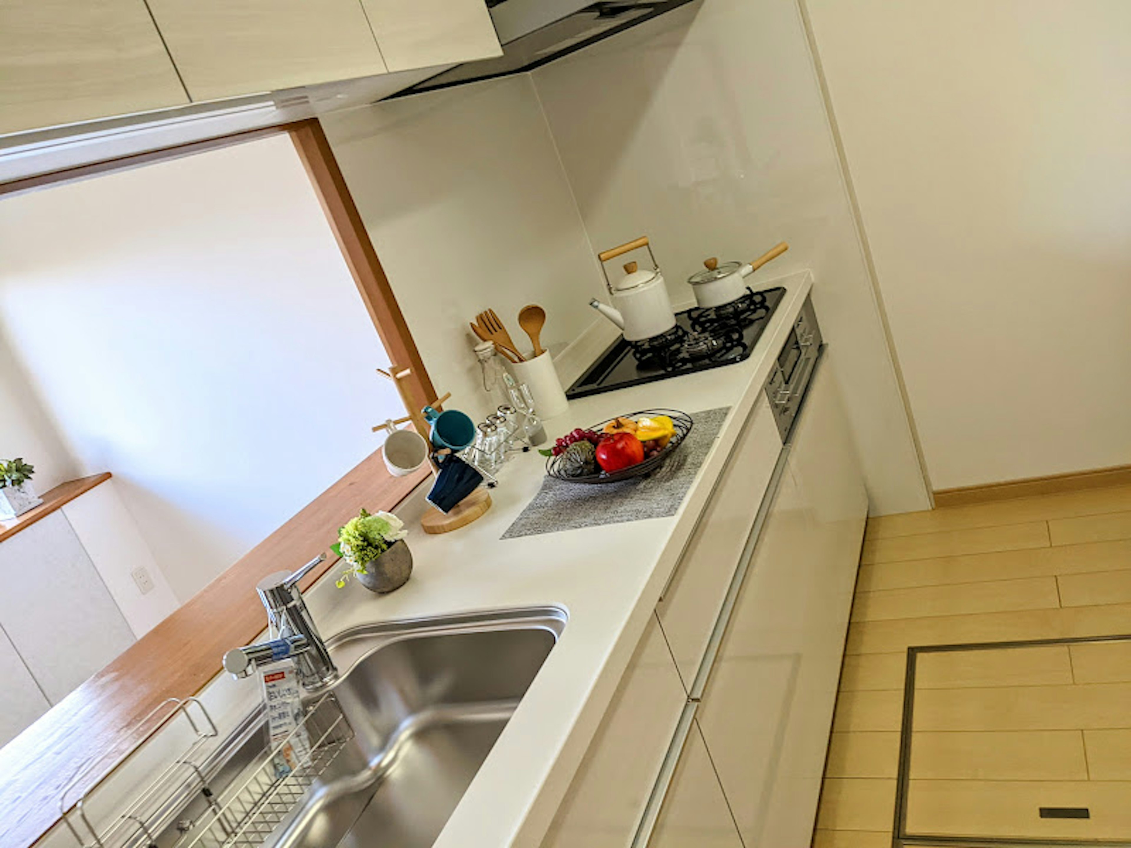 Bright kitchen with simple furniture design featuring fruits and kitchen utensils on the counter