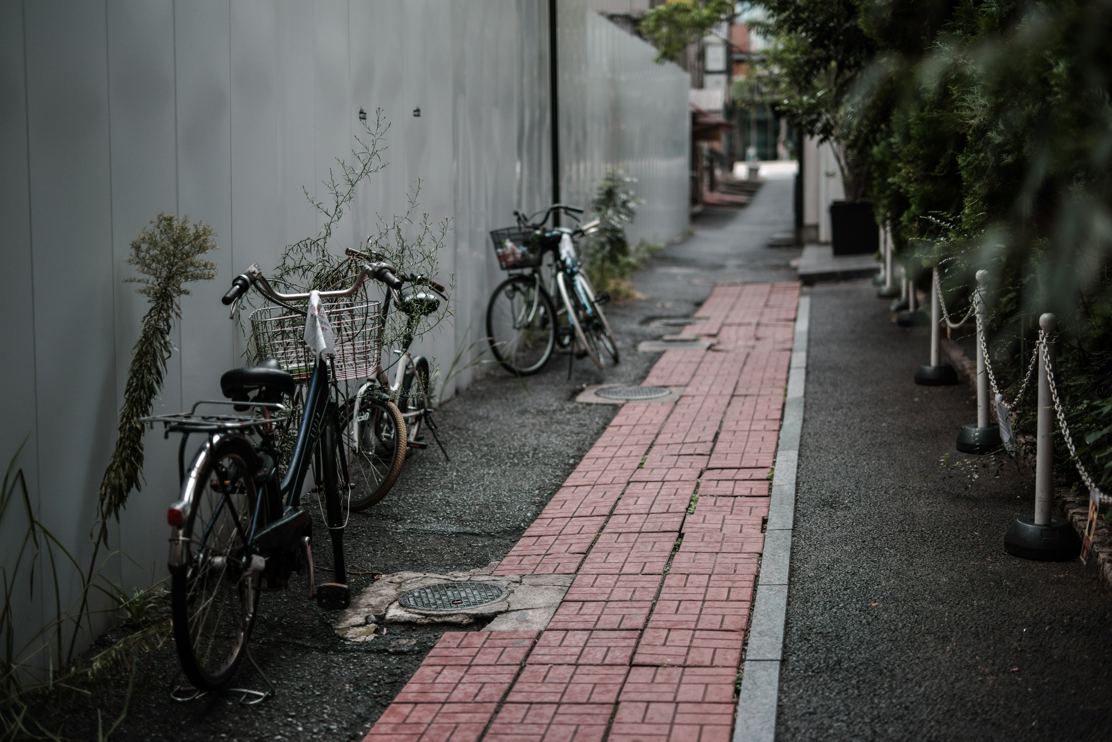 狭い通りに停められた自転車と赤いタイルの歩道