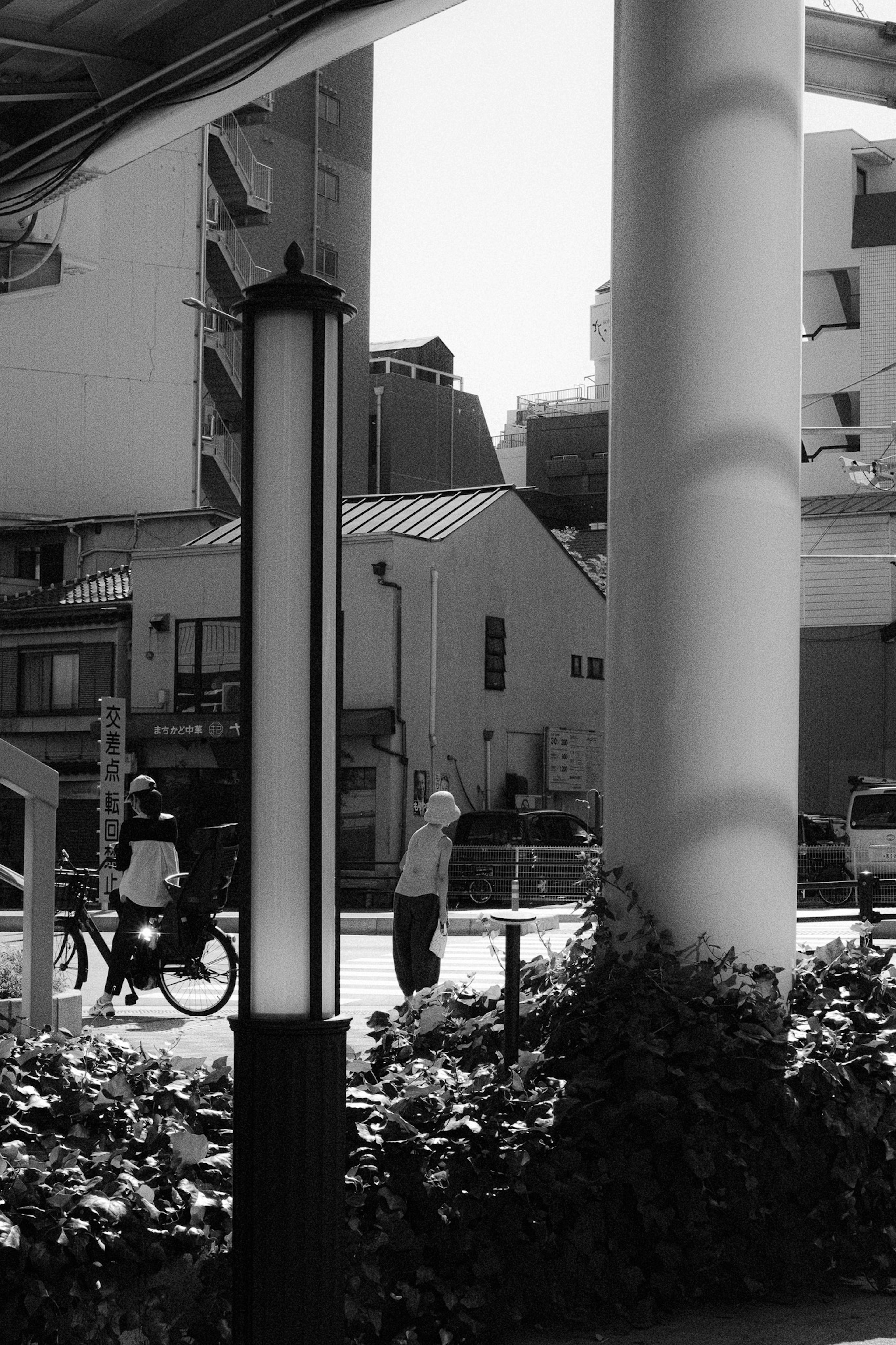 Black and white urban scene featuring a cyclist and a pedestrian