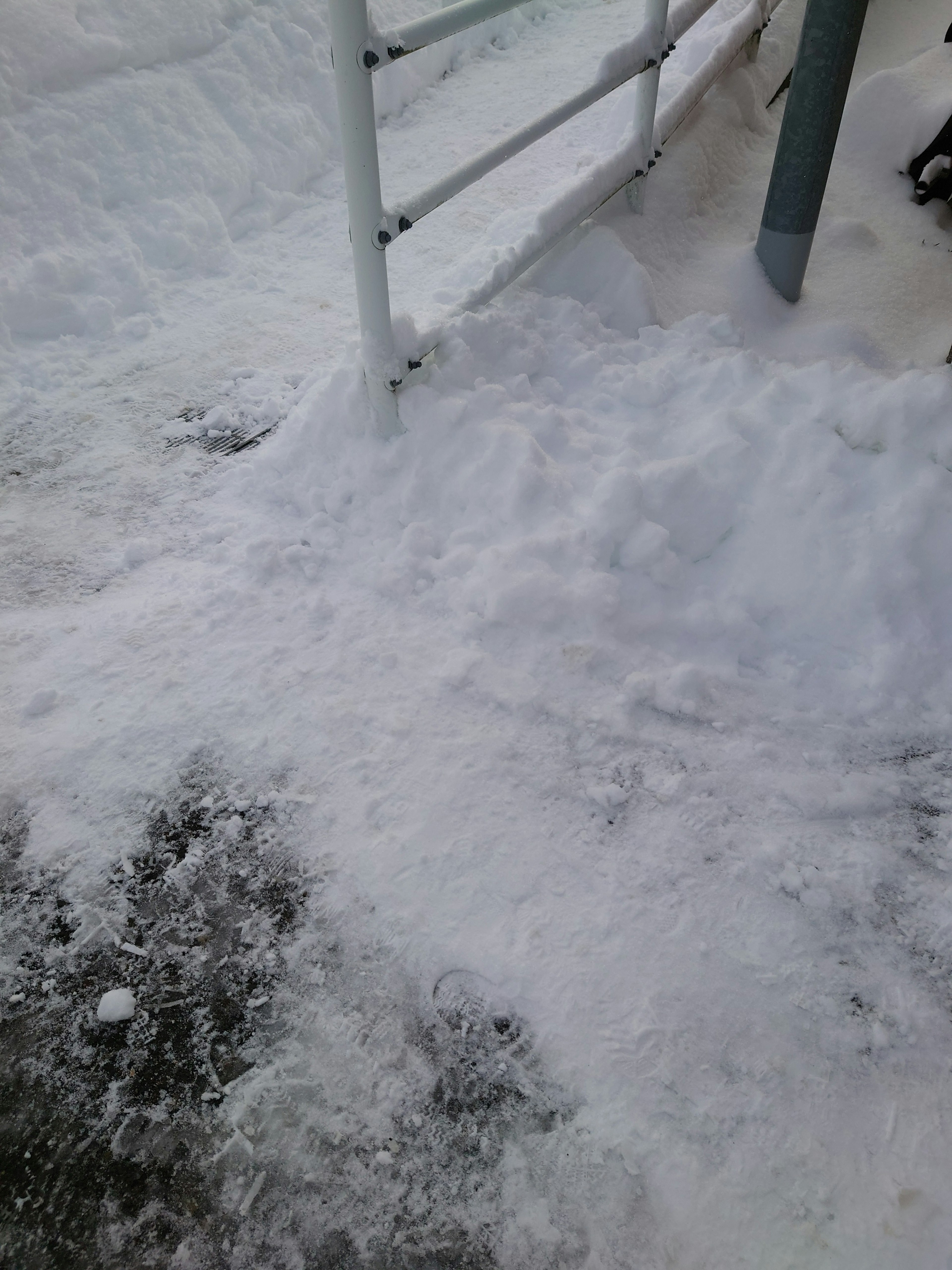 Snow-covered ground with a section of fence