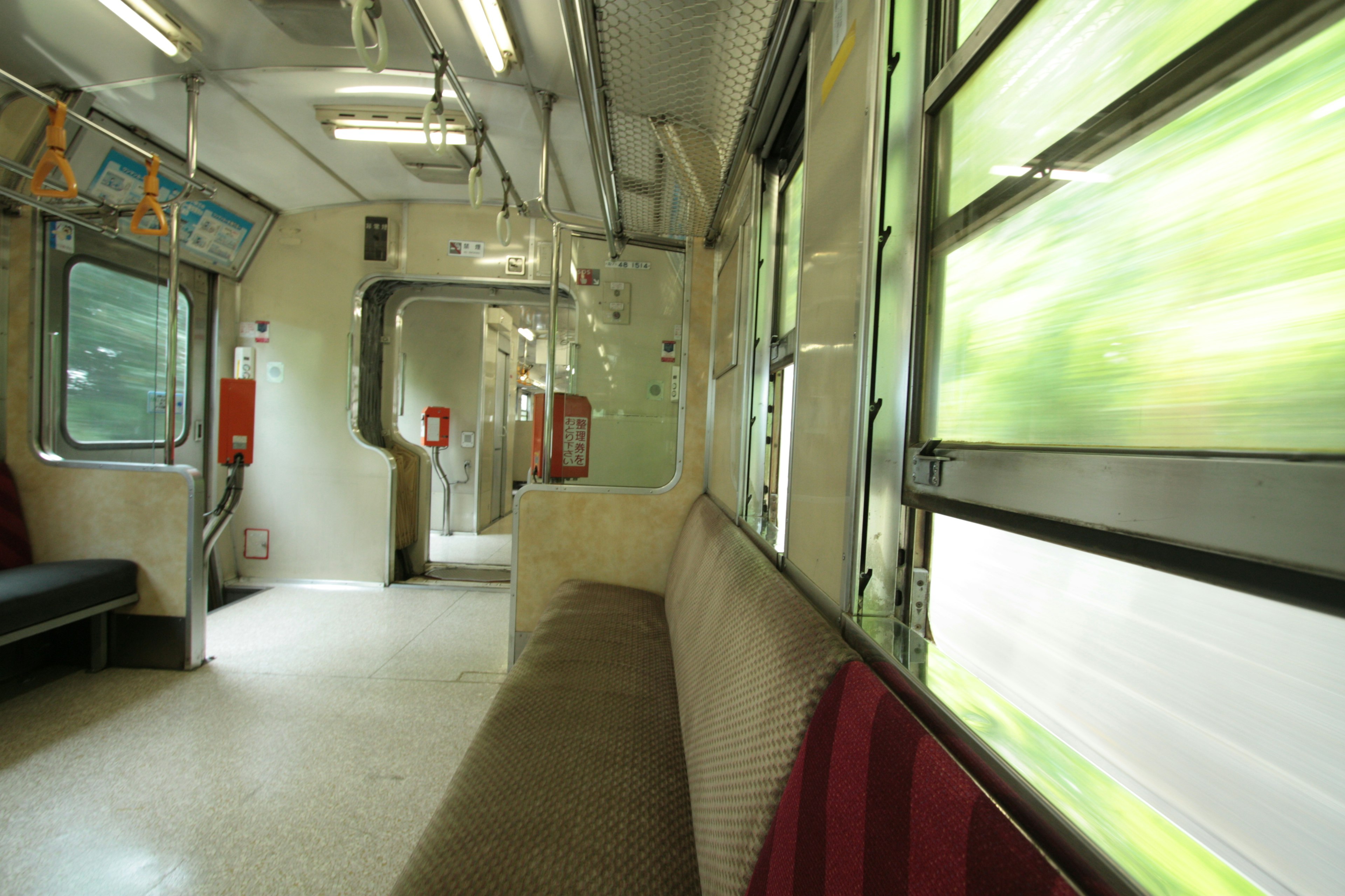 Vue intérieure d'un wagon de train avec un paysage vert visible par la fenêtre