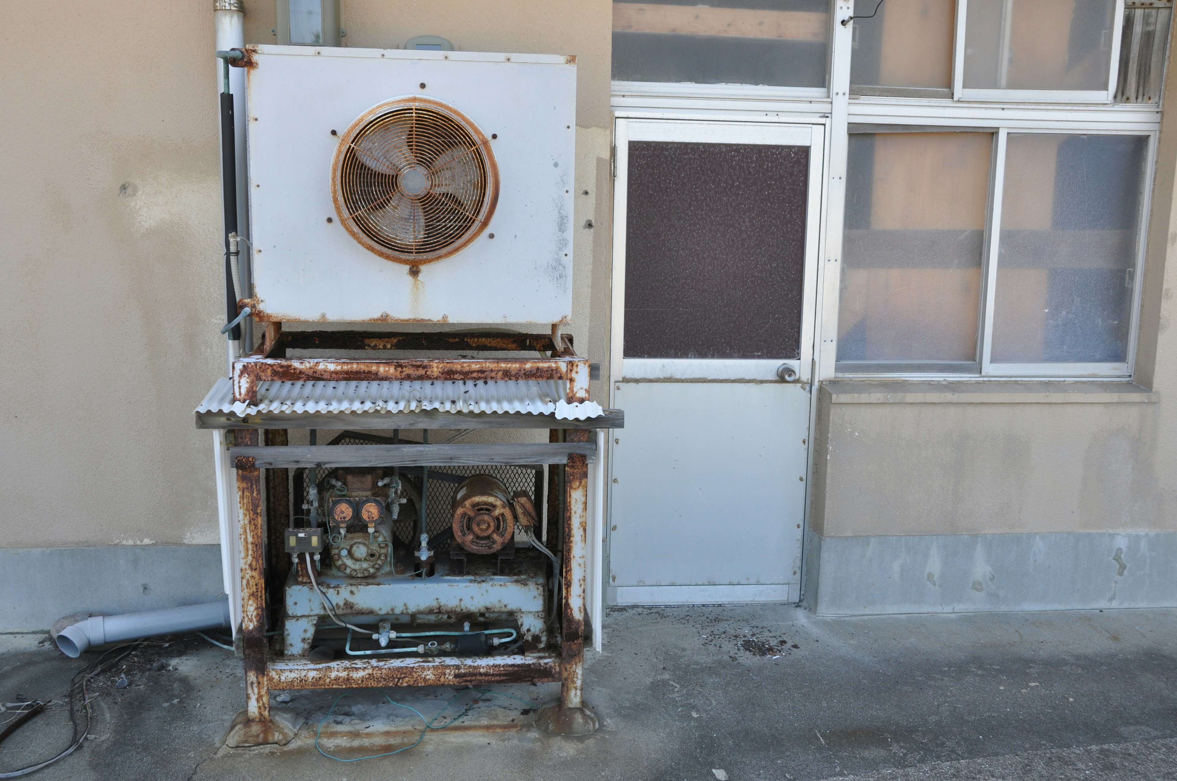 Alte Kühlanlage neben einer Tür und einem Fenster