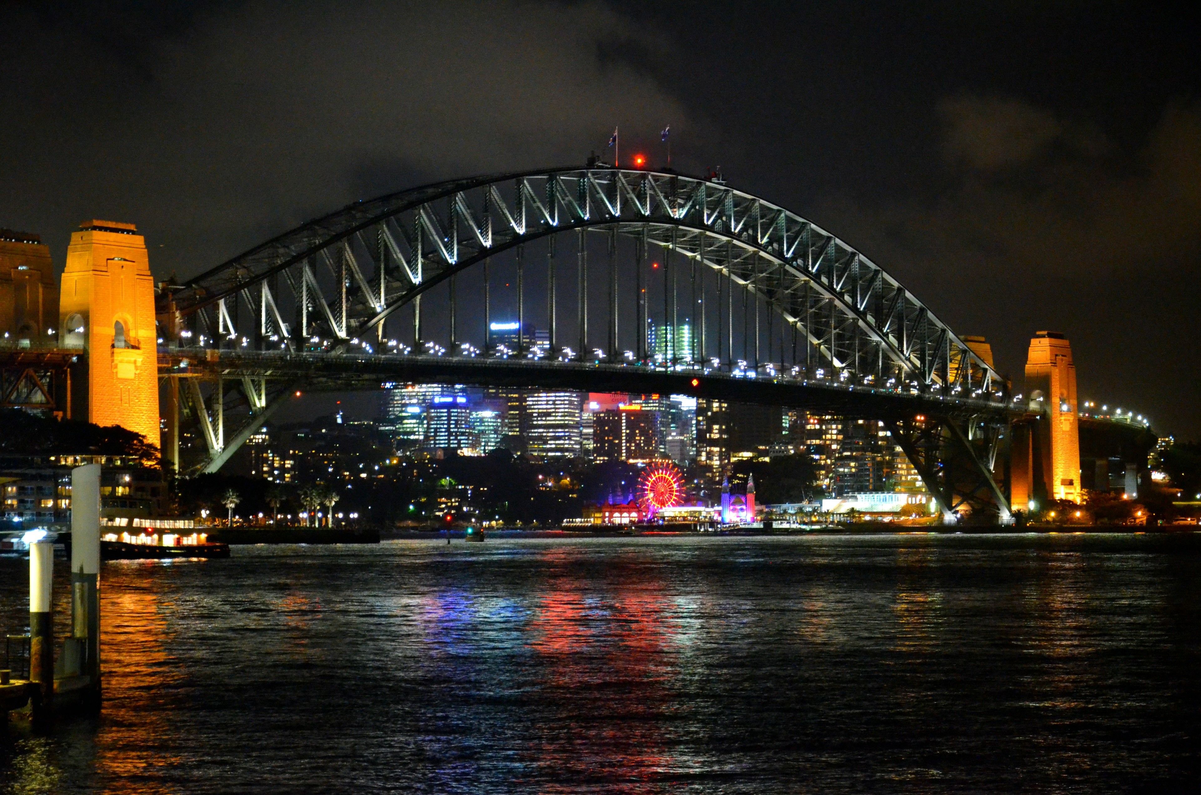 Jembatan Pelabuhan Sydney yang diterangi di malam hari dengan cakrawala kota