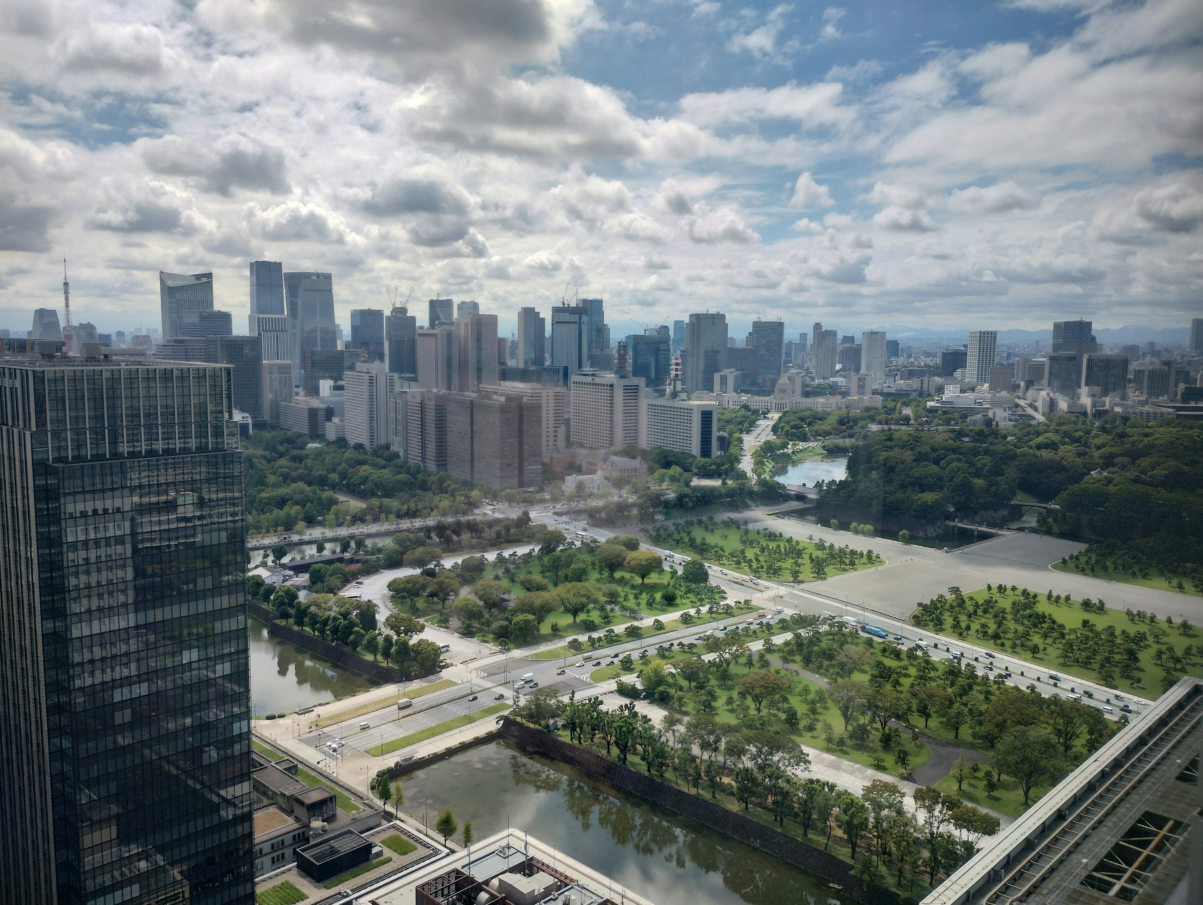 Urban landscape viewed from a high-rise building featuring lush parks and waterways