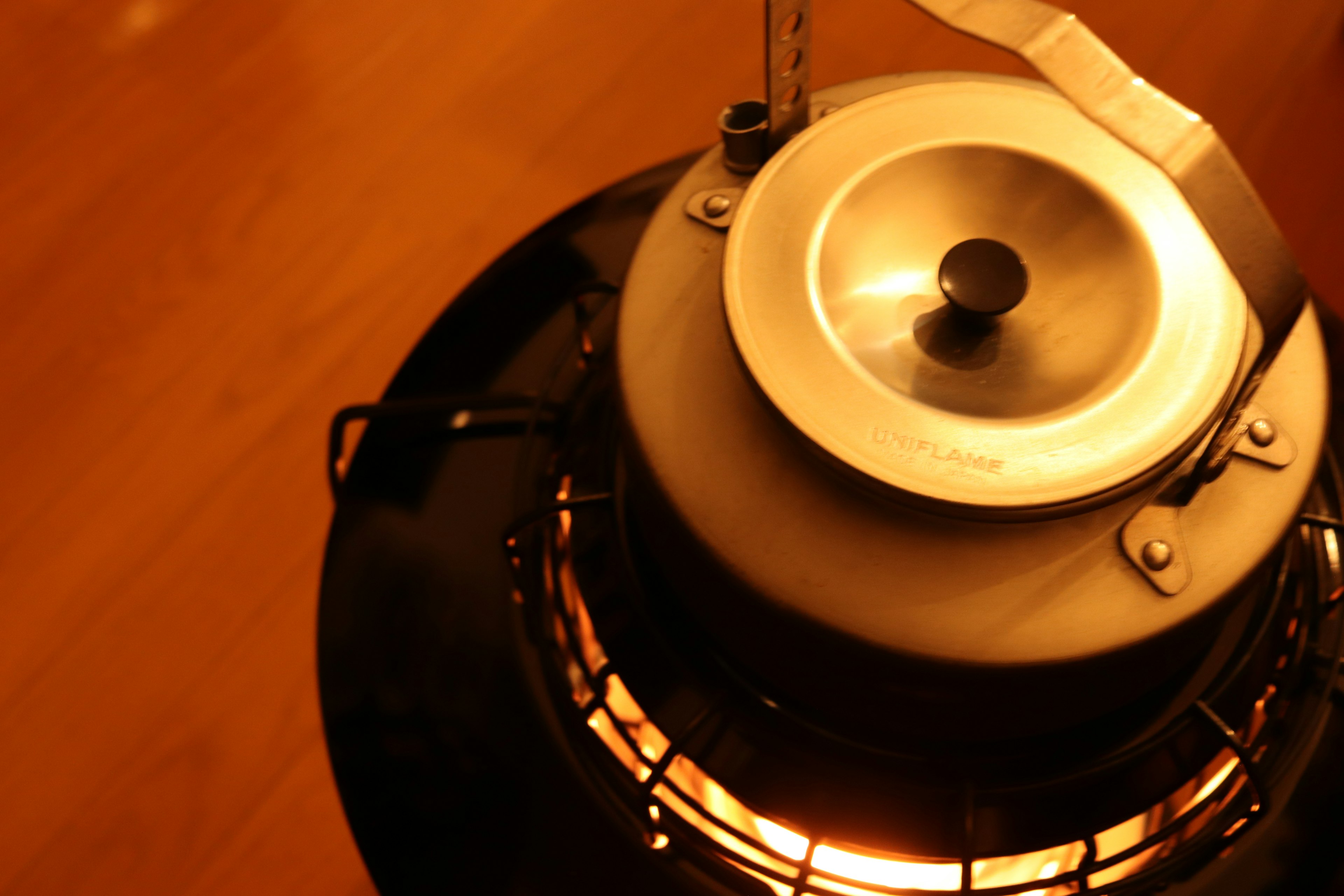 Close-up of a stove emitting warm light featuring metal components and a simple design