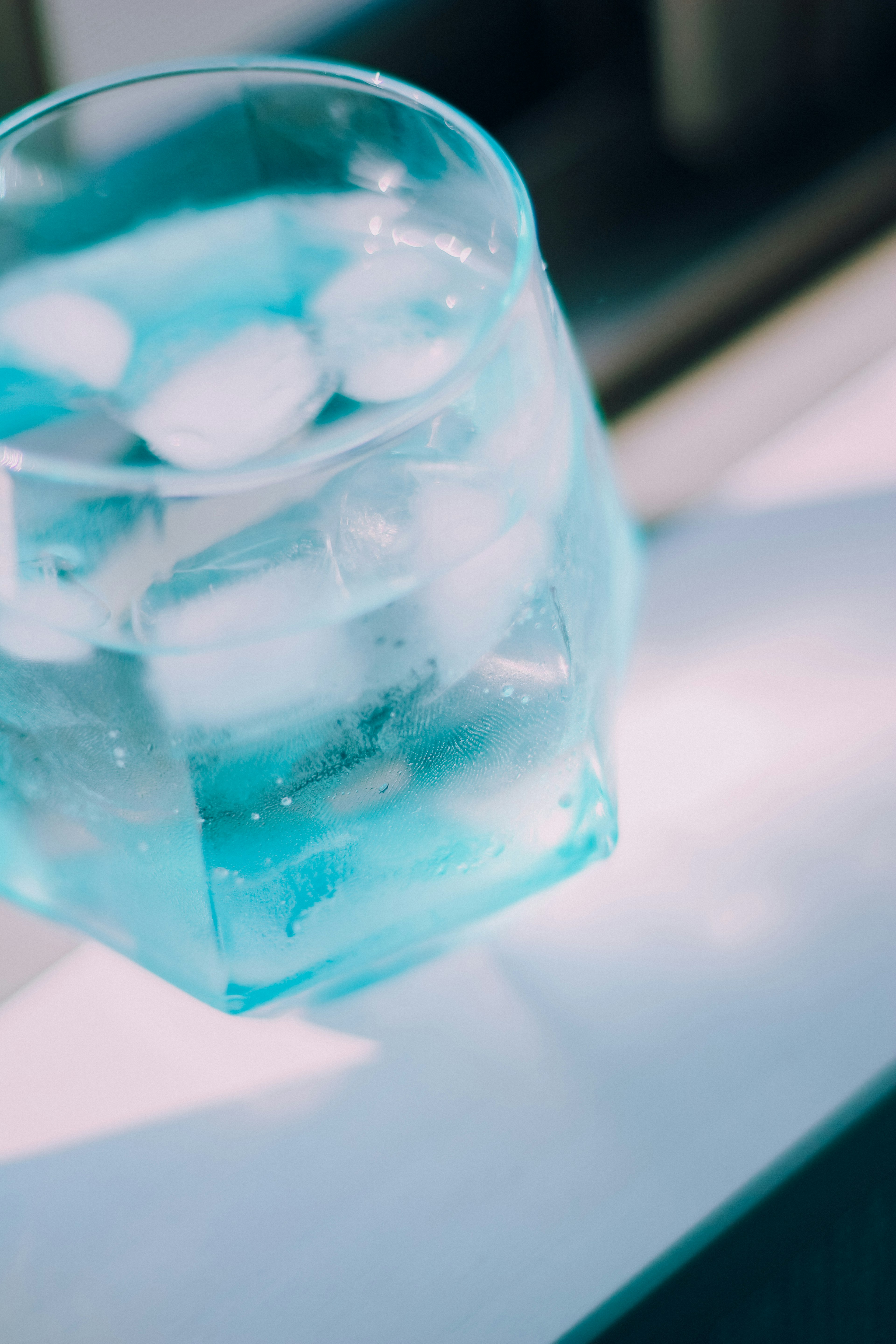 Clear blue glass with ice cubes and water