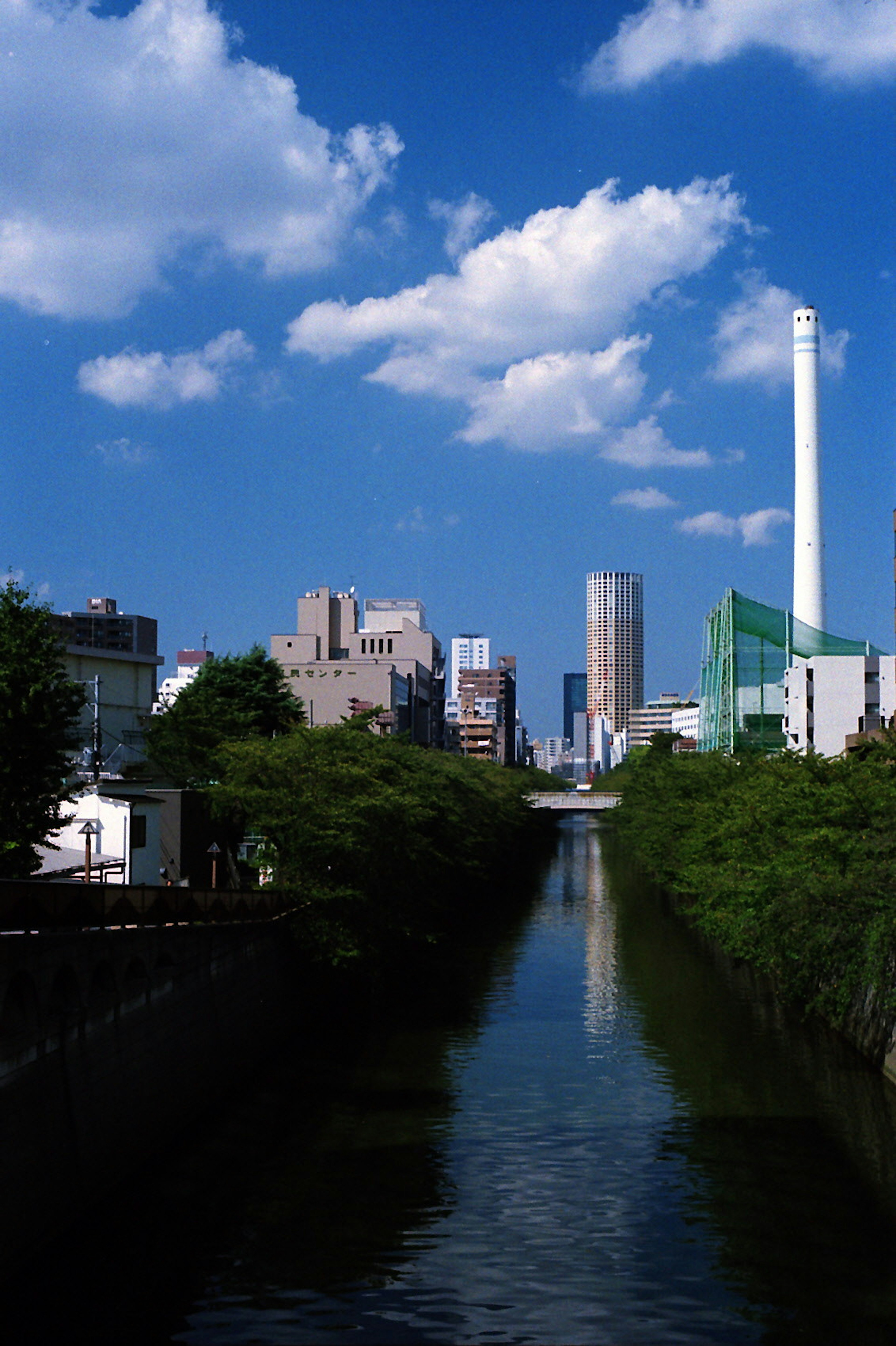 Urban landscape along a river with blue sky and clouds