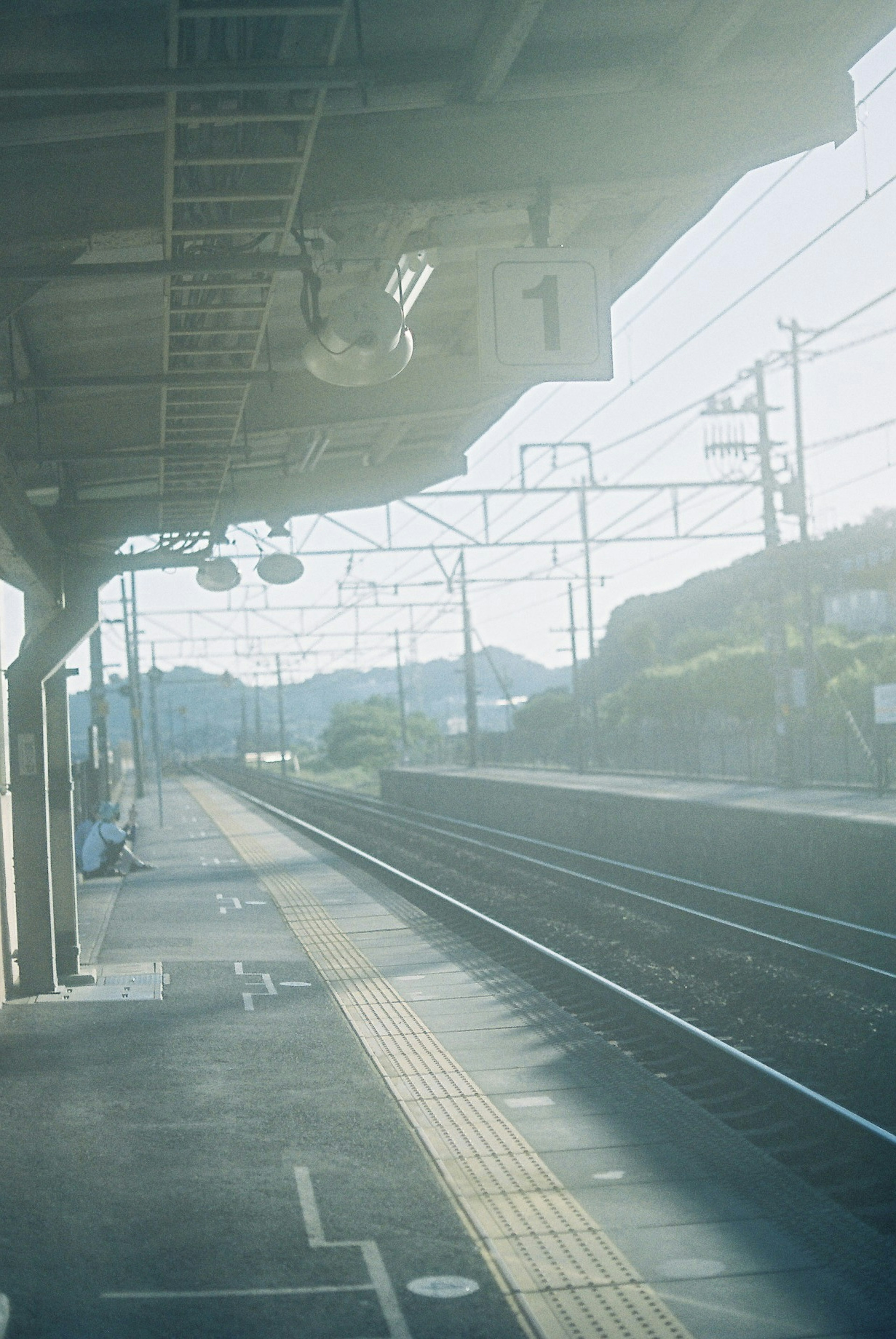 駅のプラットフォームと線路の風景、柔らかな光に包まれた風景