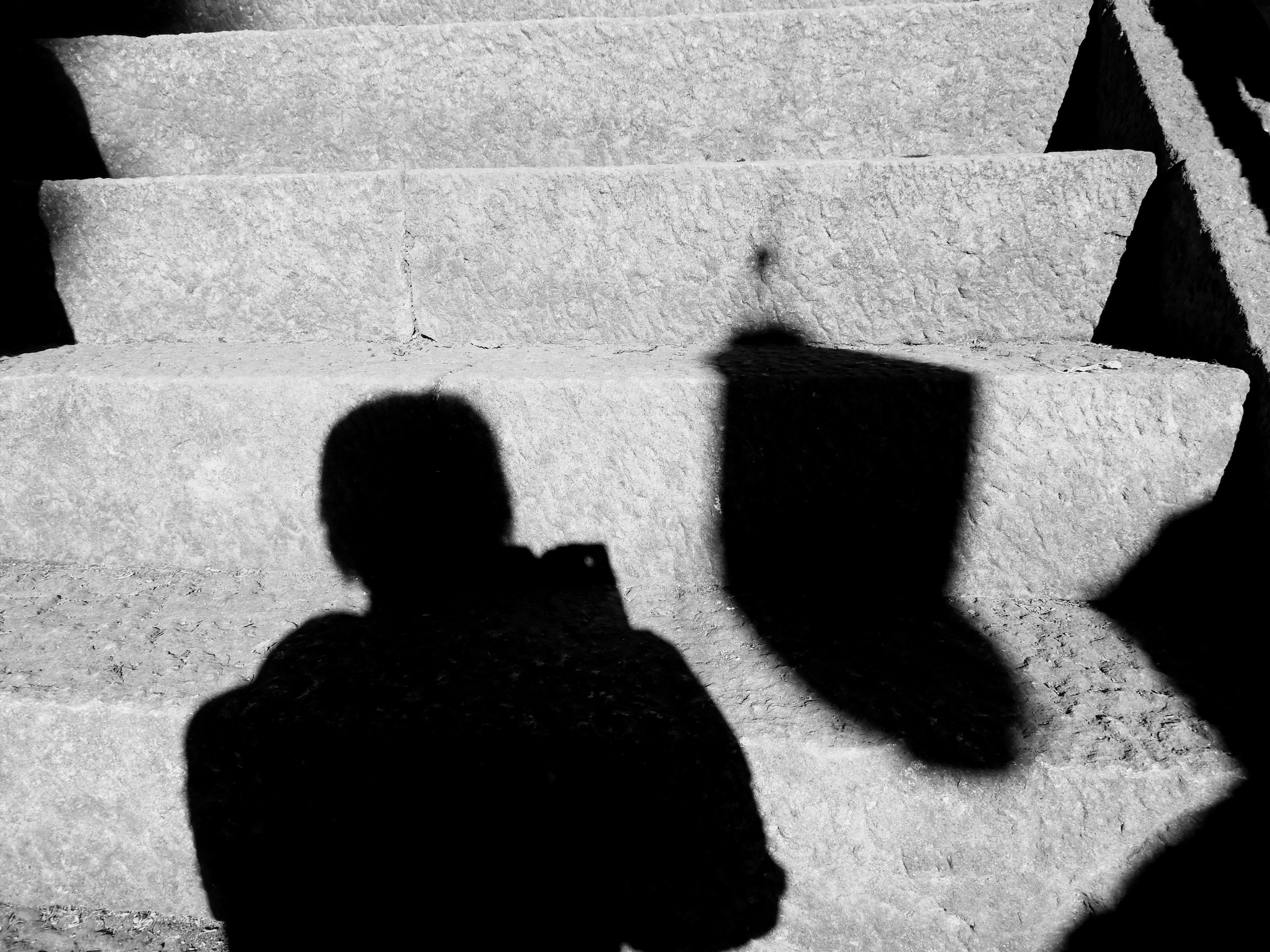 Schwarzweißbild von Treppen mit dem Schatten einer Person