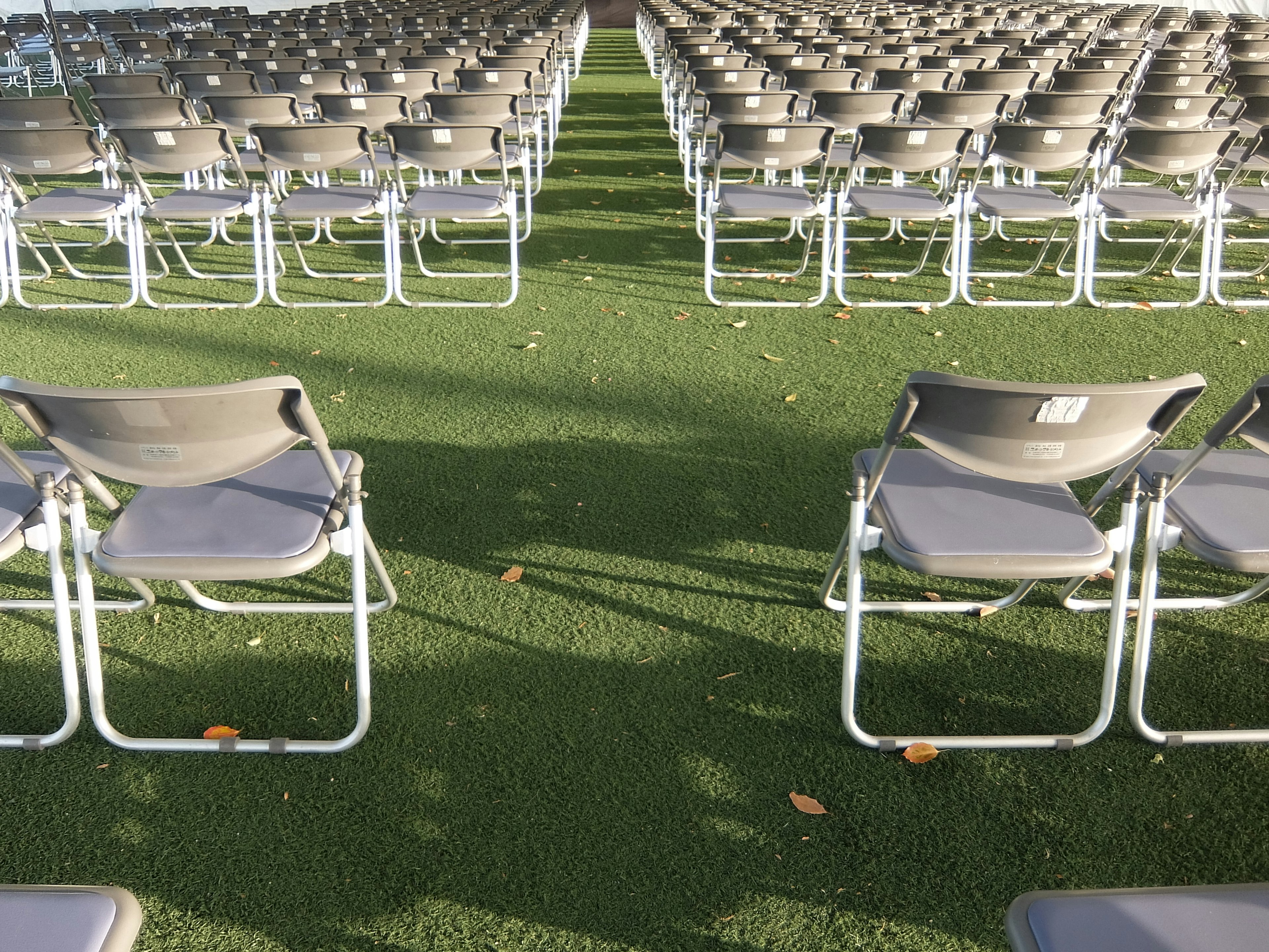 Neatly arranged gray chairs on artificial grass