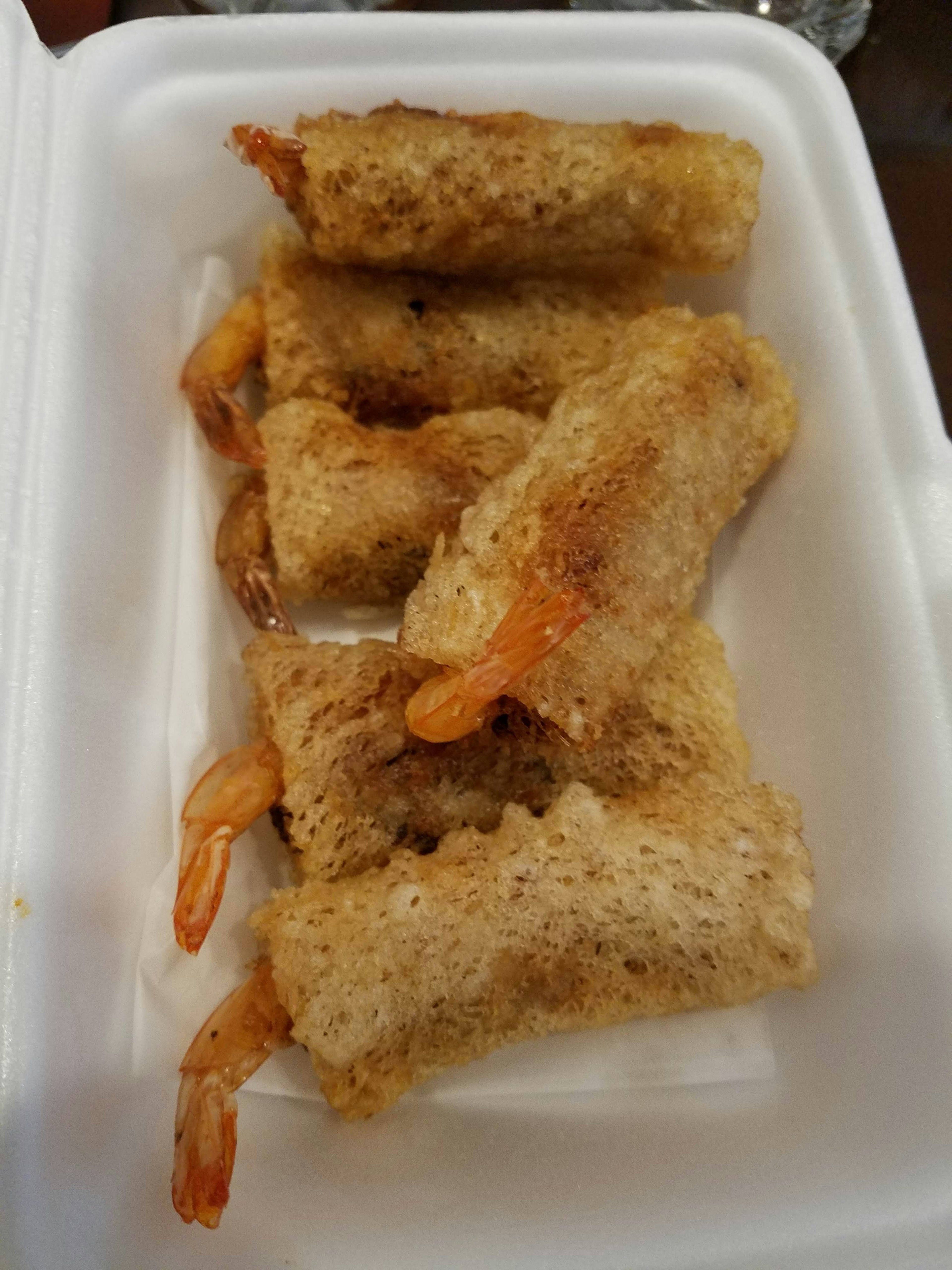 Fried shrimp rice rolls arranged in a takeout container