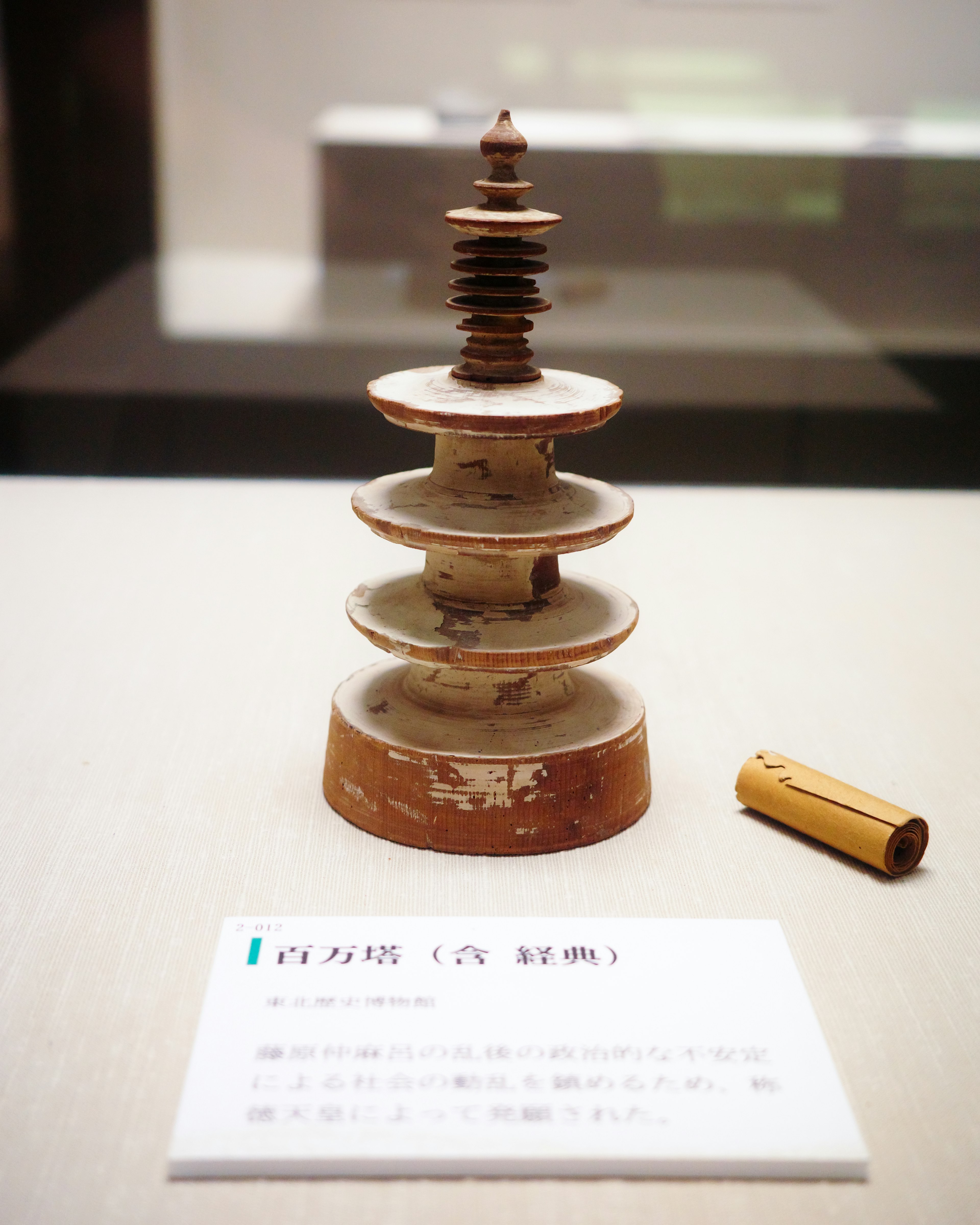 Ceramic model of a stupa with a small cylindrical object beside it