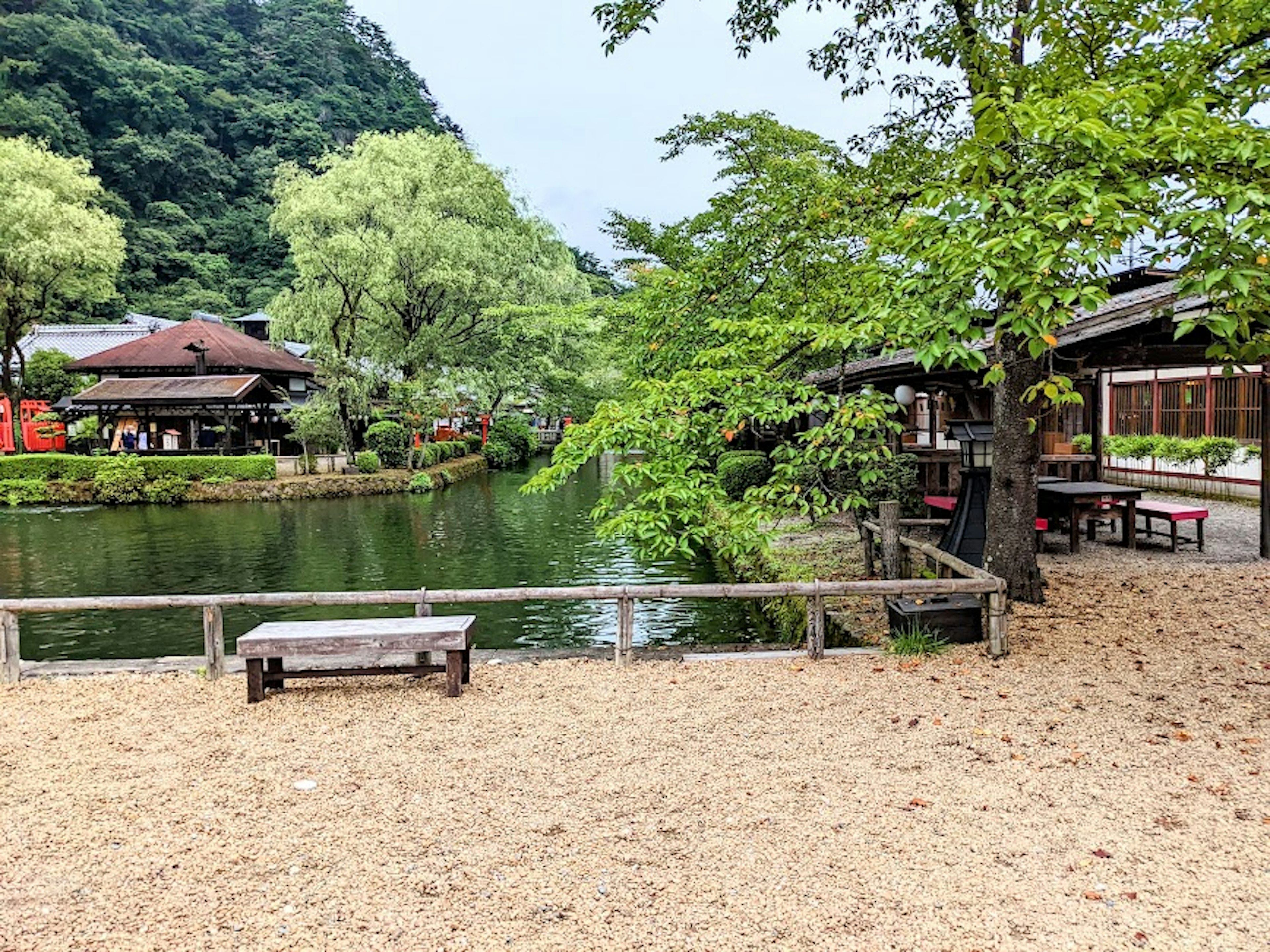 宁静池塘旁的传统日本建筑与郁郁葱葱的树木