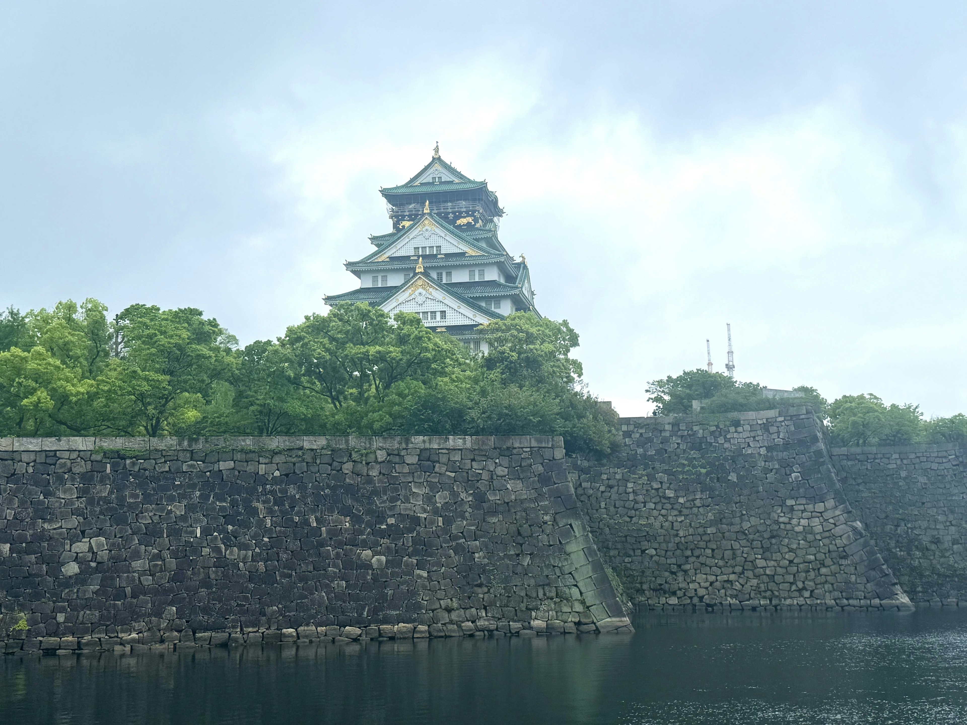 Château d'Osaka entouré de verdure et de murs en pierre