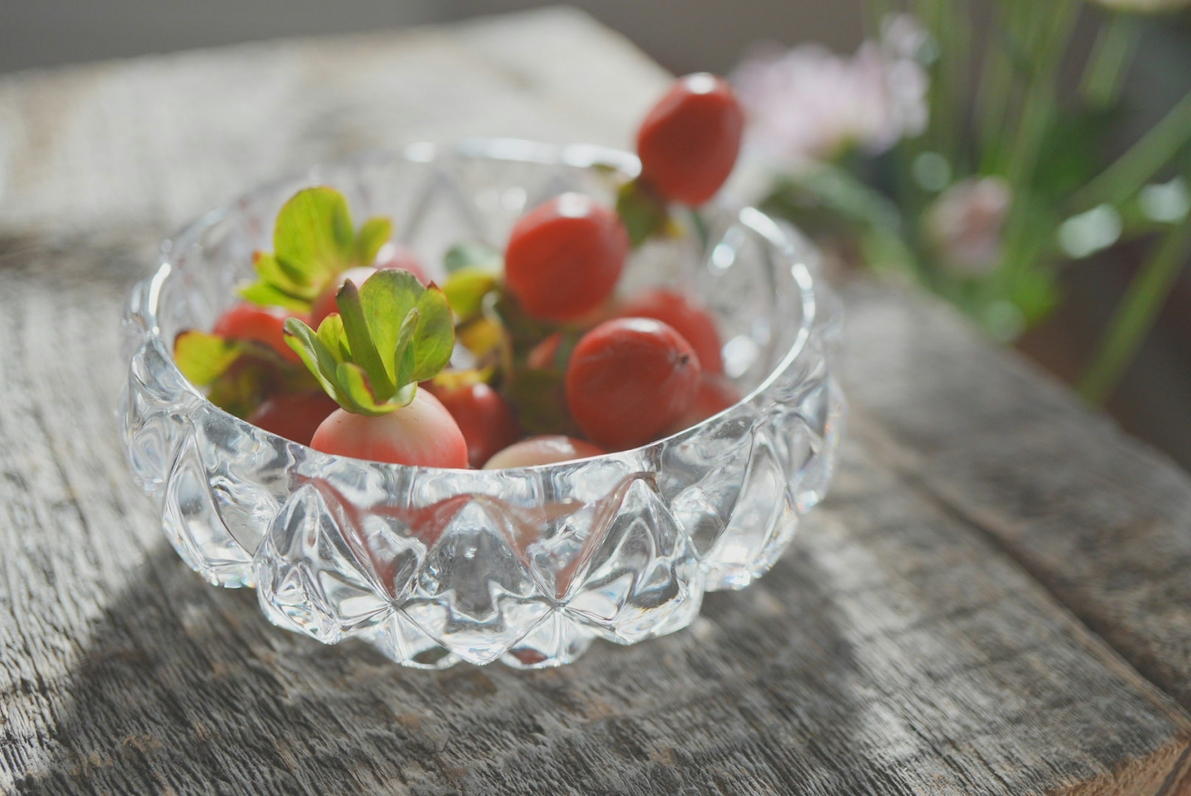 Fresh strawberries and leaves in a crystal bowl