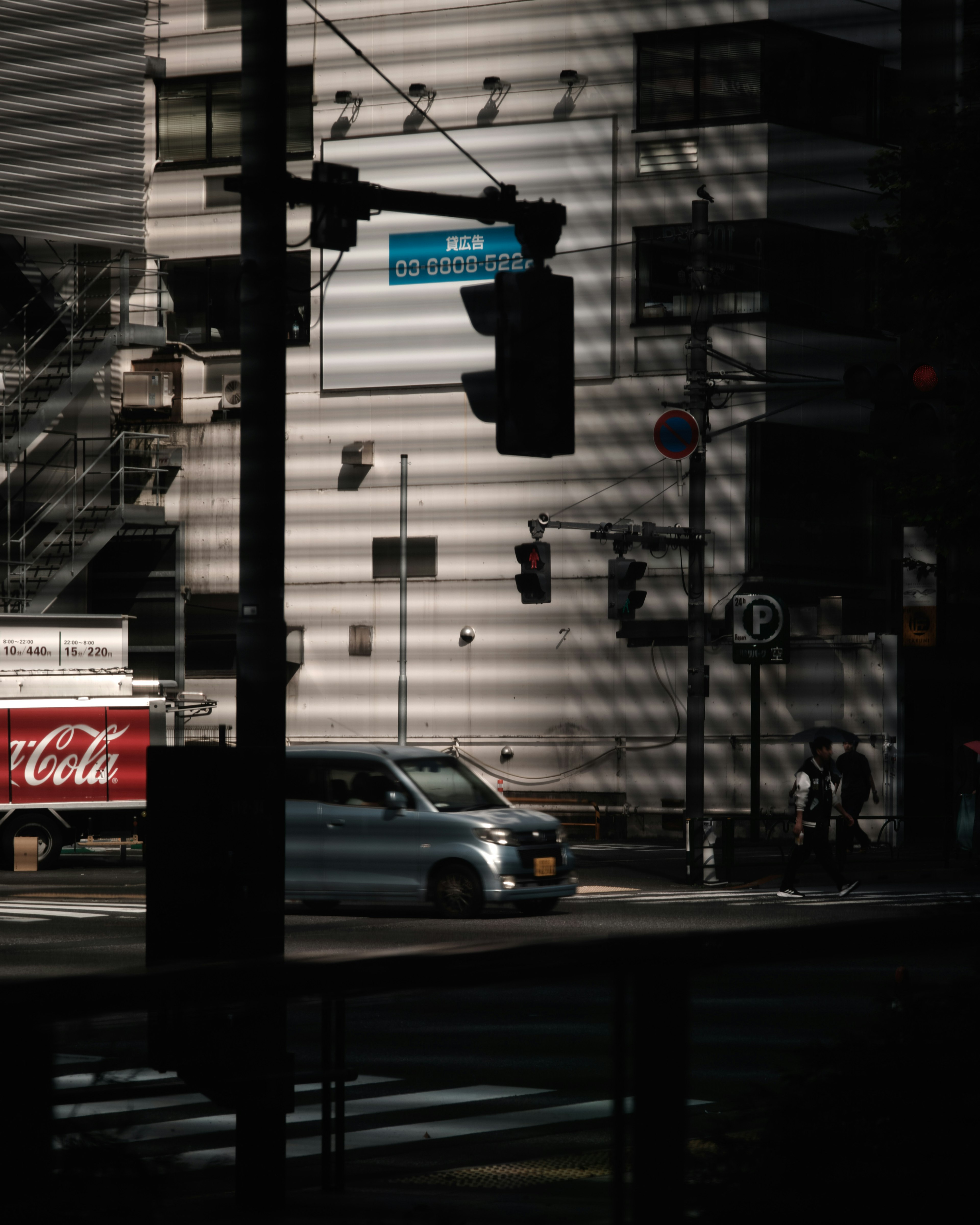 Paesaggio urbano con un camion Coca-Cola e semafori nell'ombra