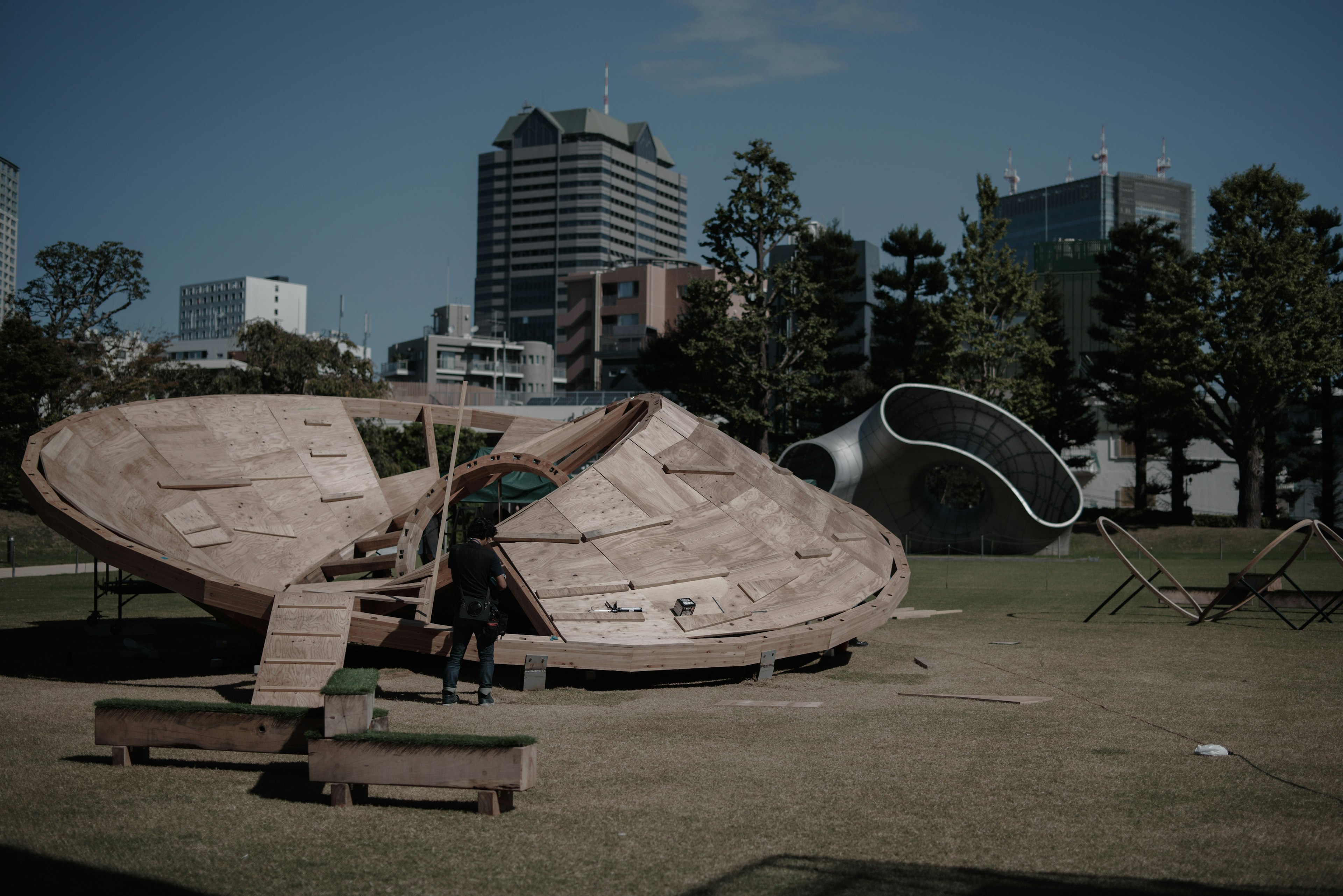 Equipo de juego en forma de nave espacial en un parque con edificios modernos de fondo