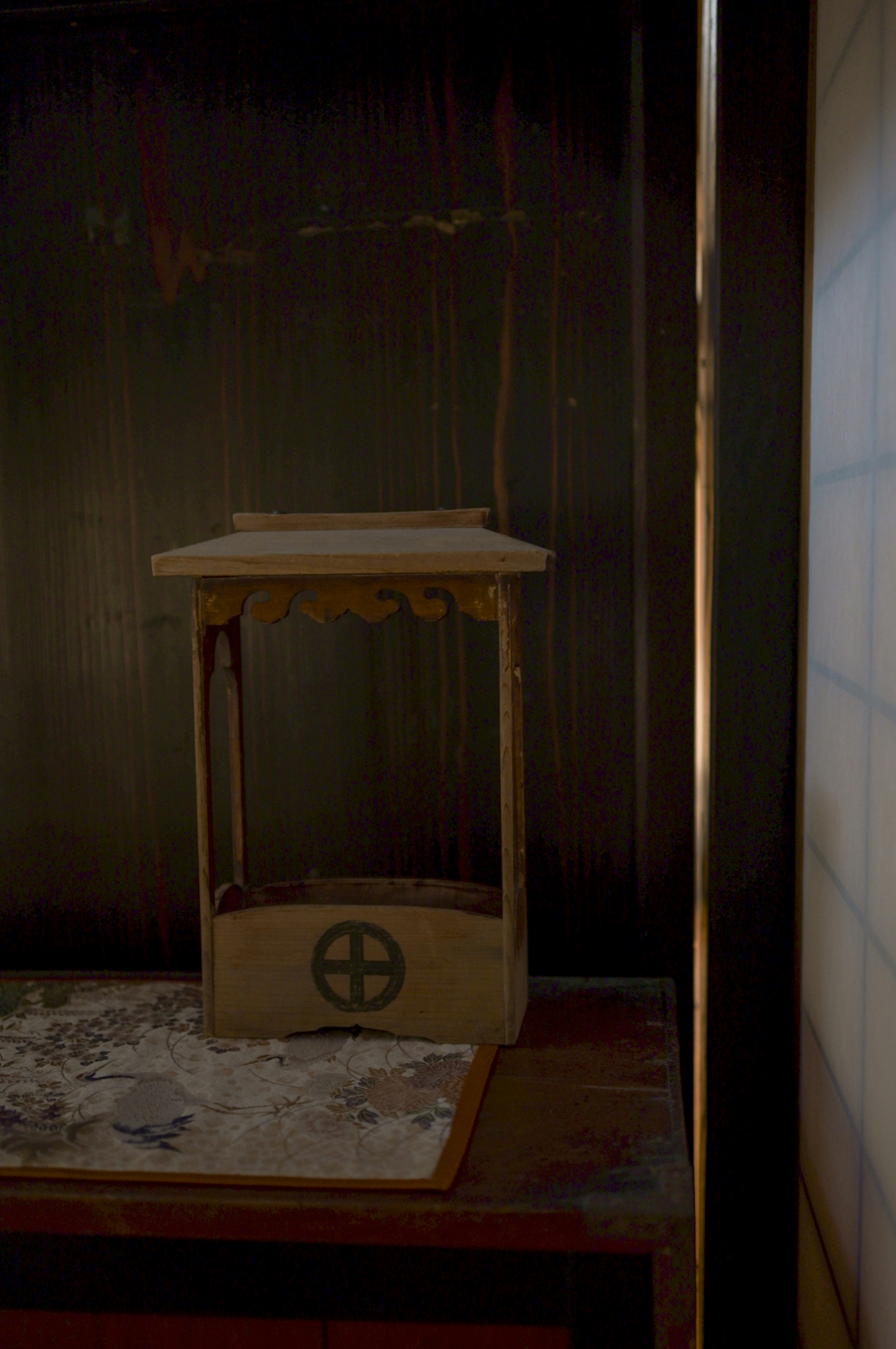 Wooden stand with a circular symbol on a dark background and white powder underneath