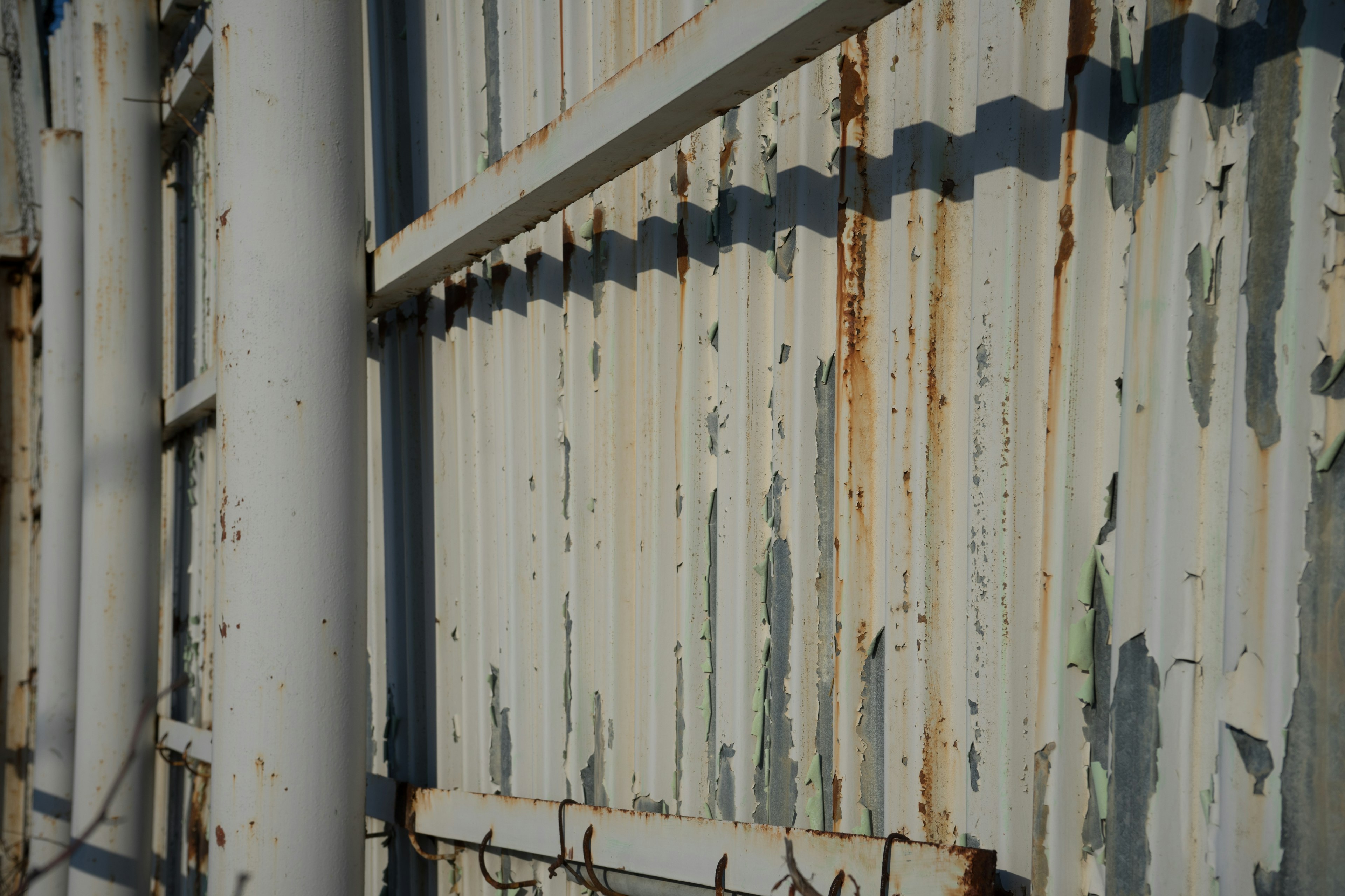 Textured metal wall with peeling paint and rust