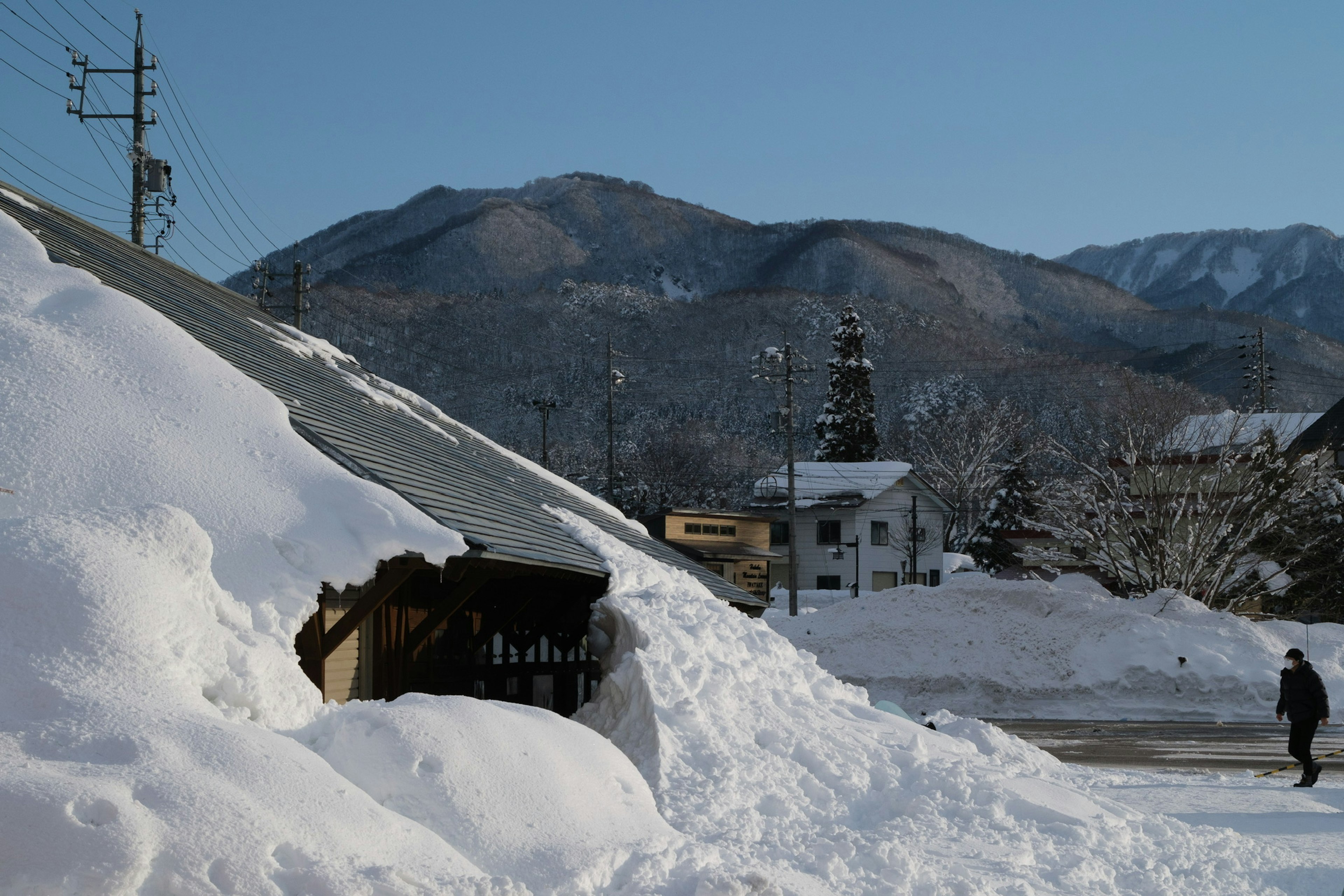 雪に覆われた屋根と山々の景色を背景にした冬の風景