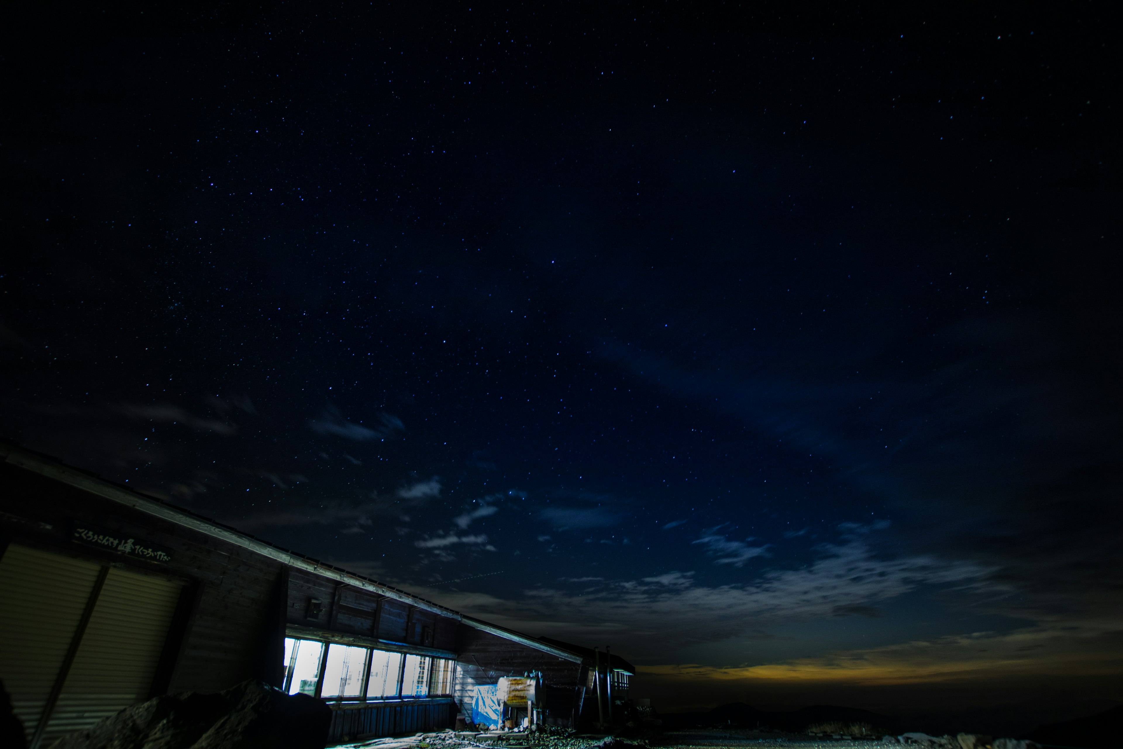 Cielo nocturno lleno de estrellas y la silueta de un edificio