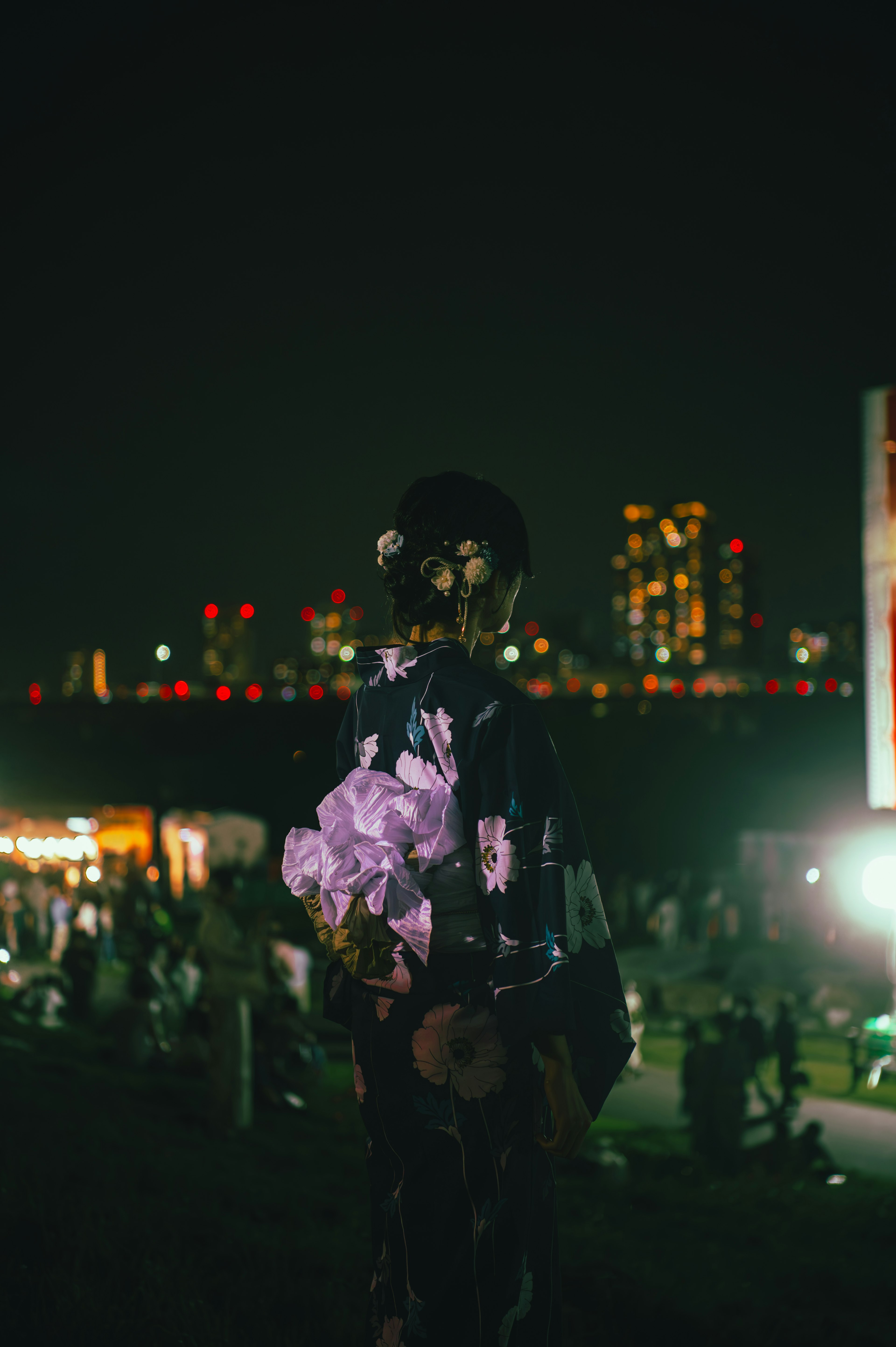 Woman holding flowers with a city skyline at night in the background