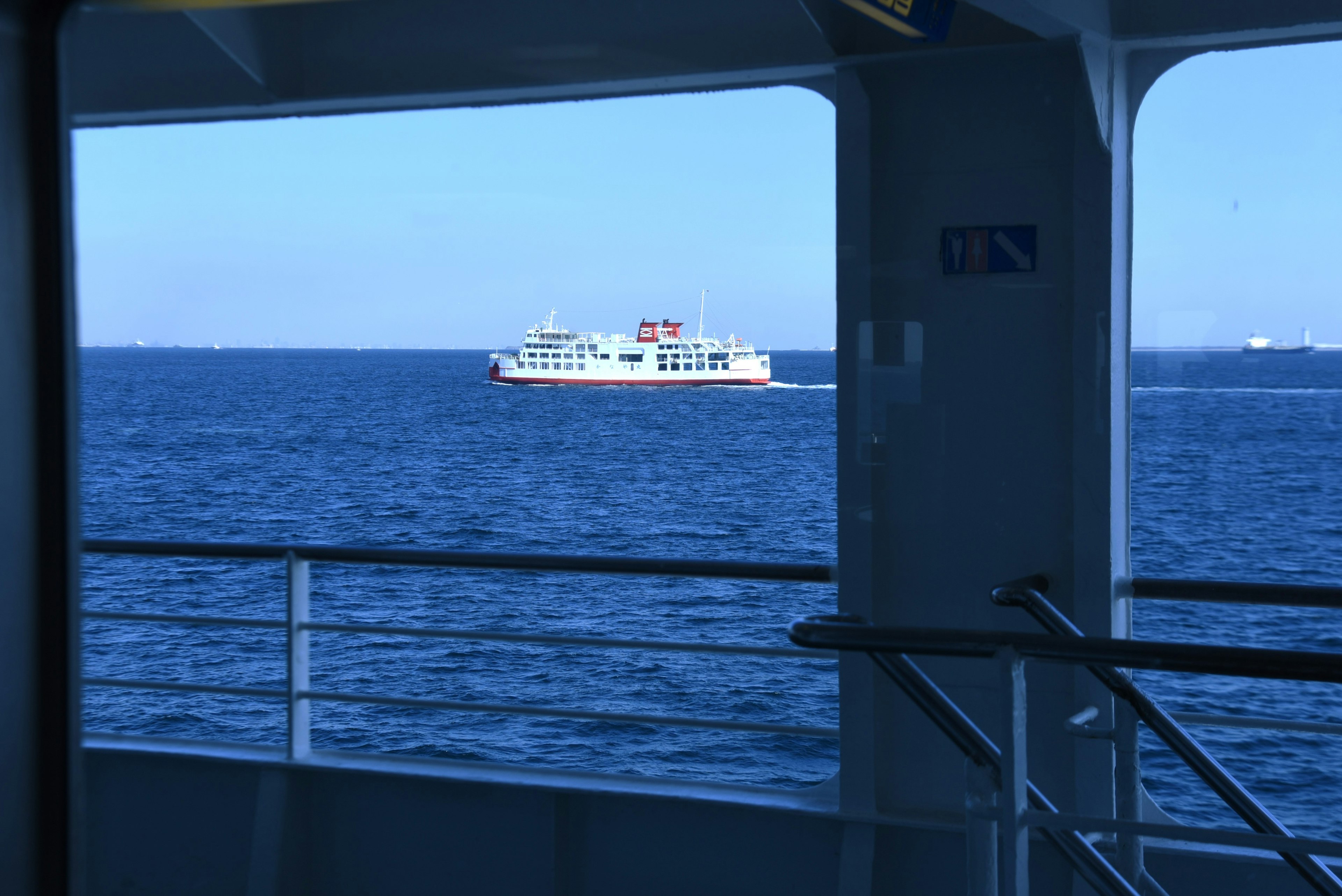 A ferry sailing on blue waters seen through a window