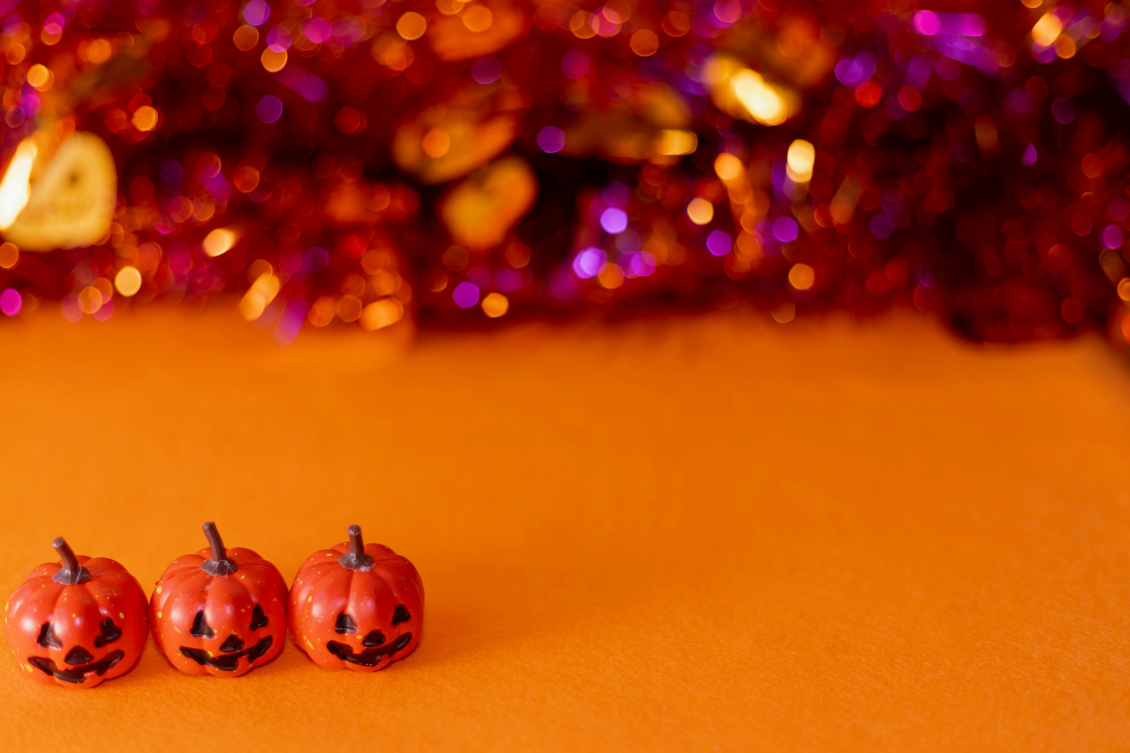 Petites décorations de citrouille grimaçante alignées sur un fond orange