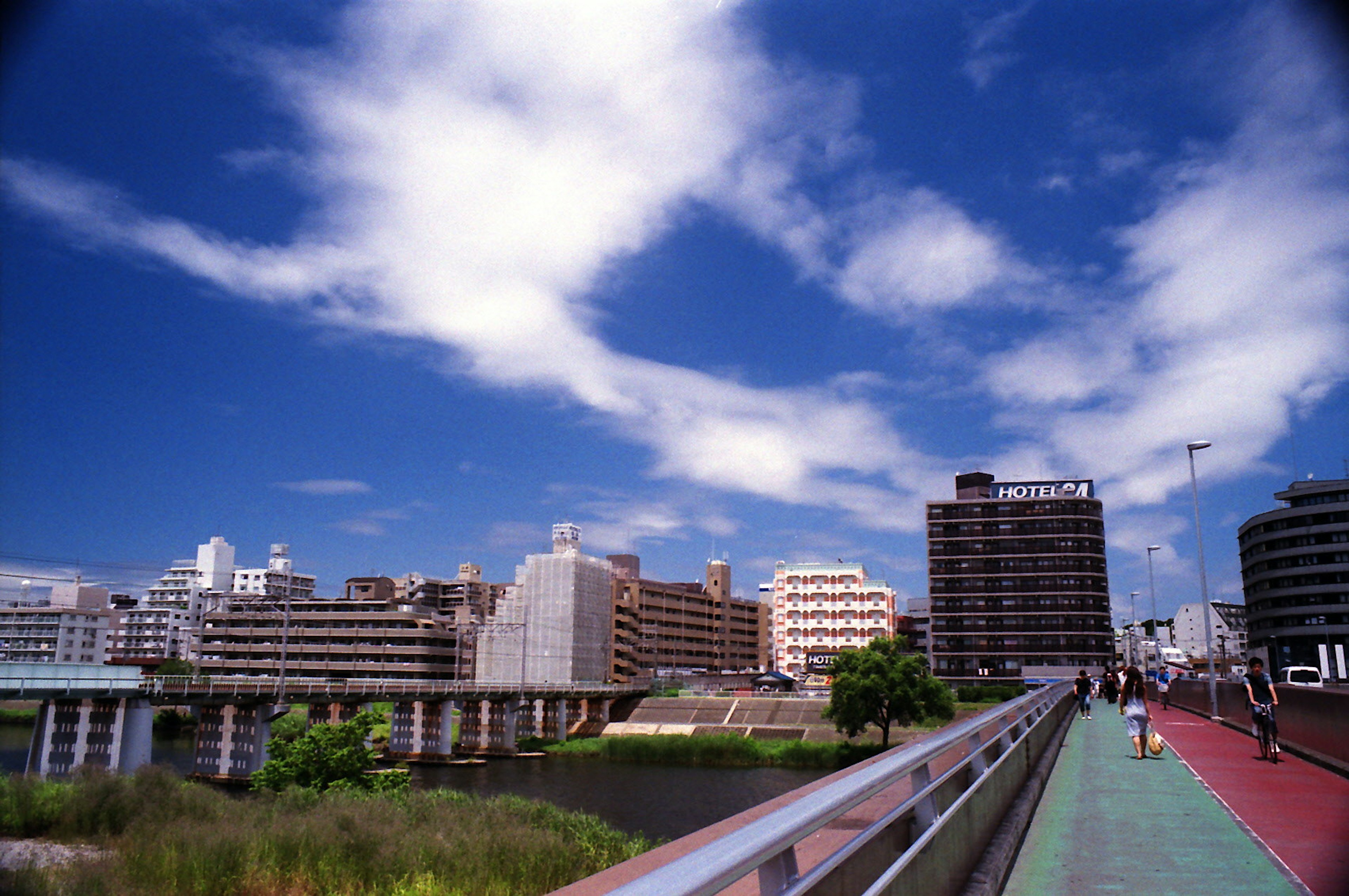 Städtische Landschaft mit blauem Himmel und Wolken, Uferpromenade und Gebäuden