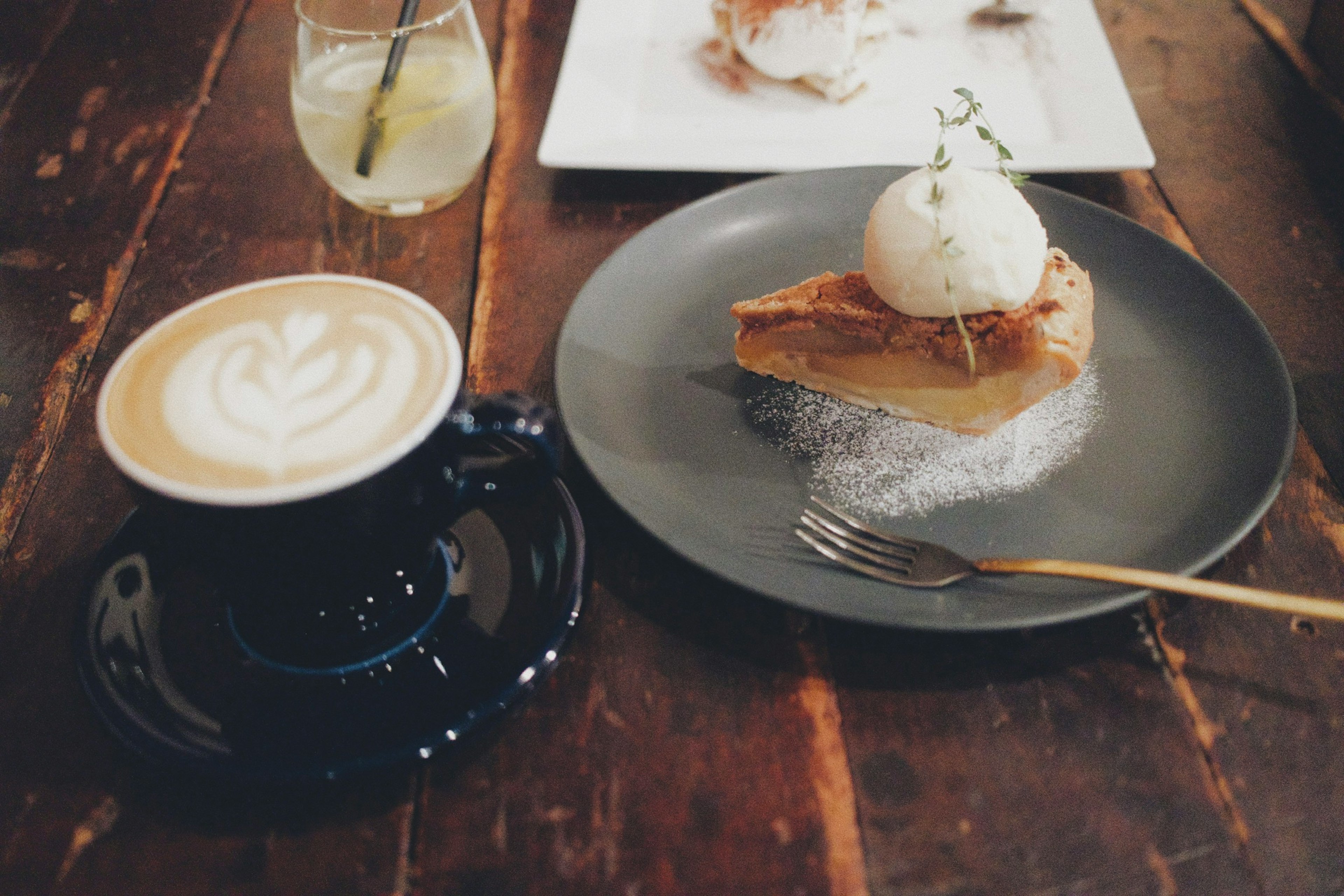 Kaffee- und Dessertanordnung mit einem Kuchen, der mit Eiscreme belegt ist