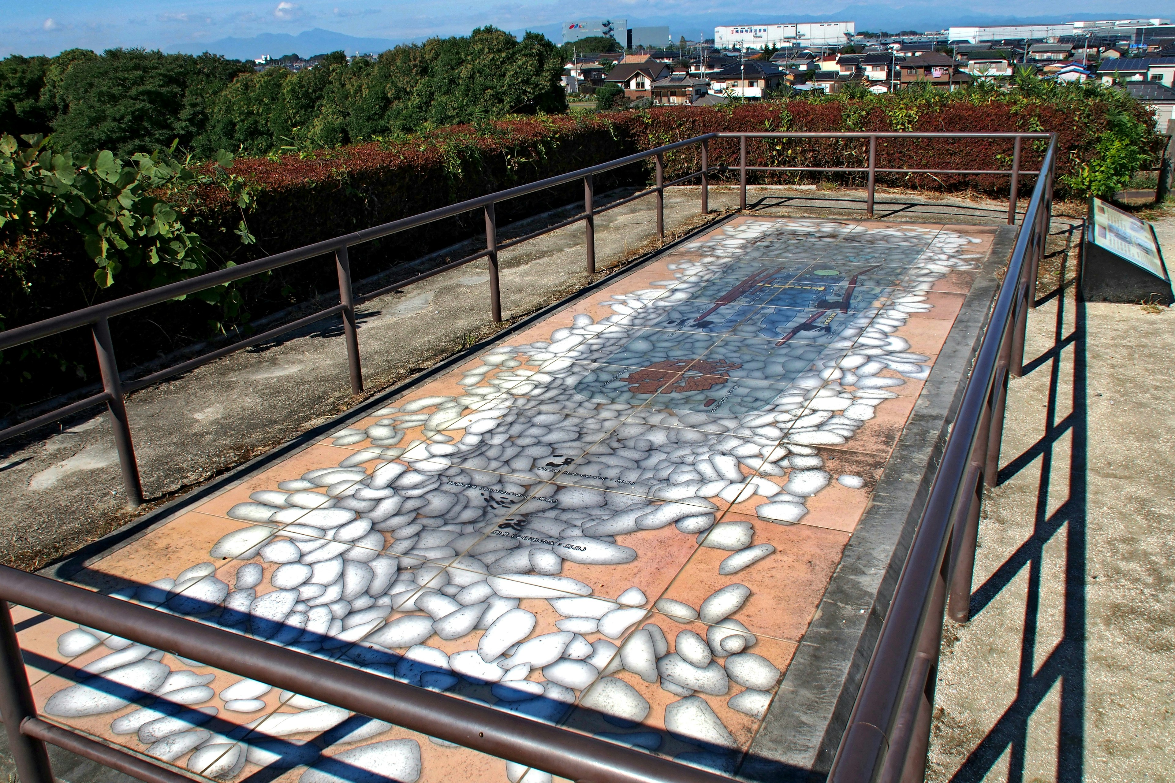 Vue d'une terrasse extérieure avec une œuvre d'art en mosaïque