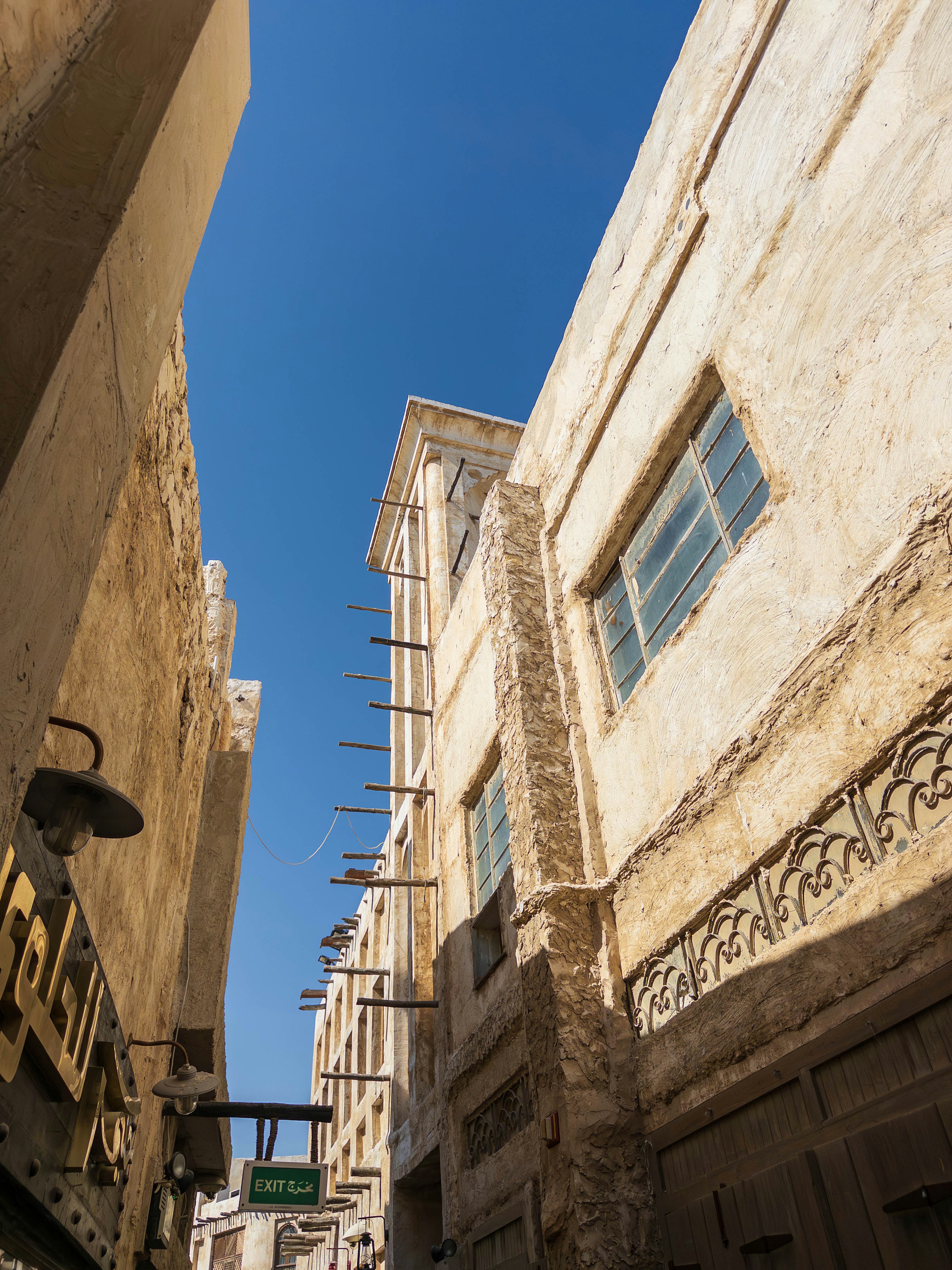 Narrow street with old buildings under a clear blue sky