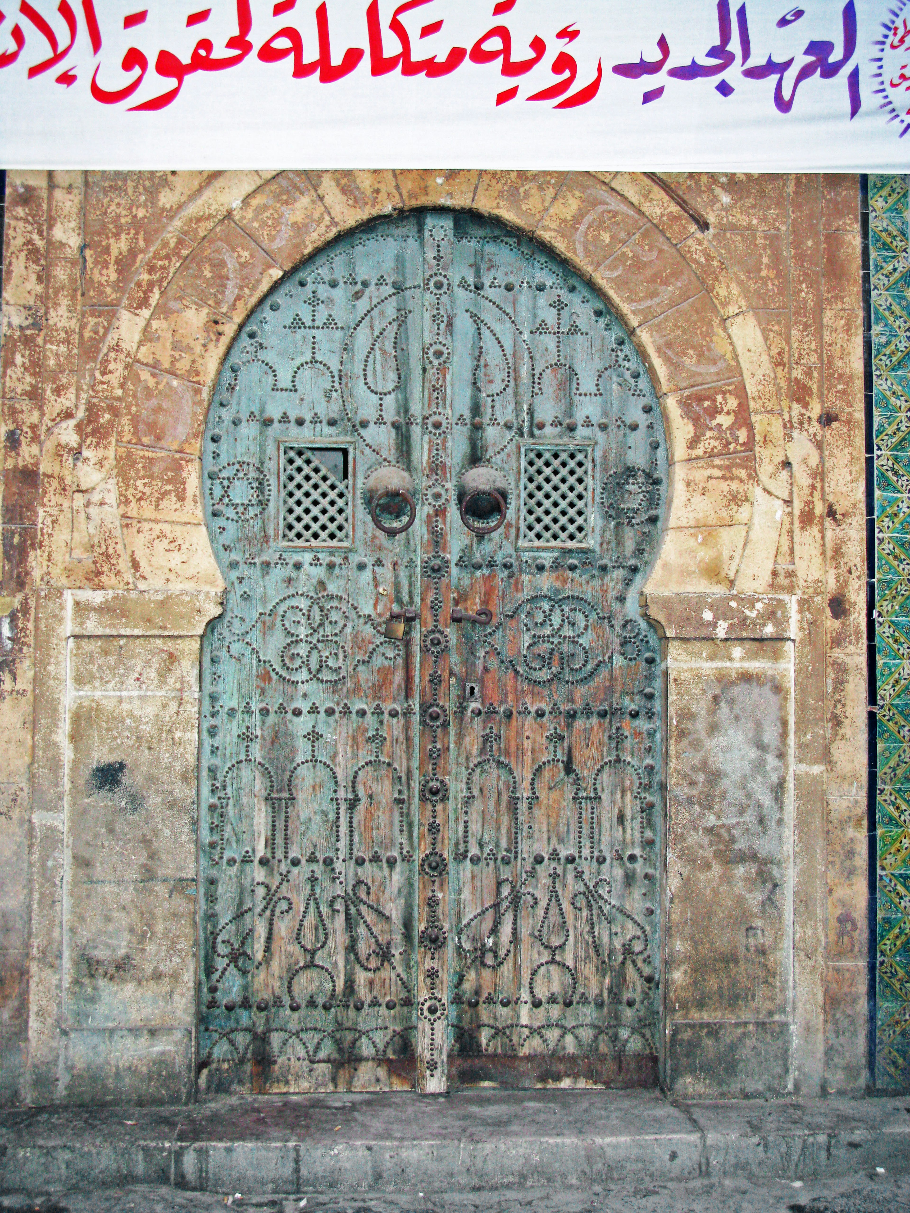 Imagen de una puerta antigua de madera con elementos decorativos azules