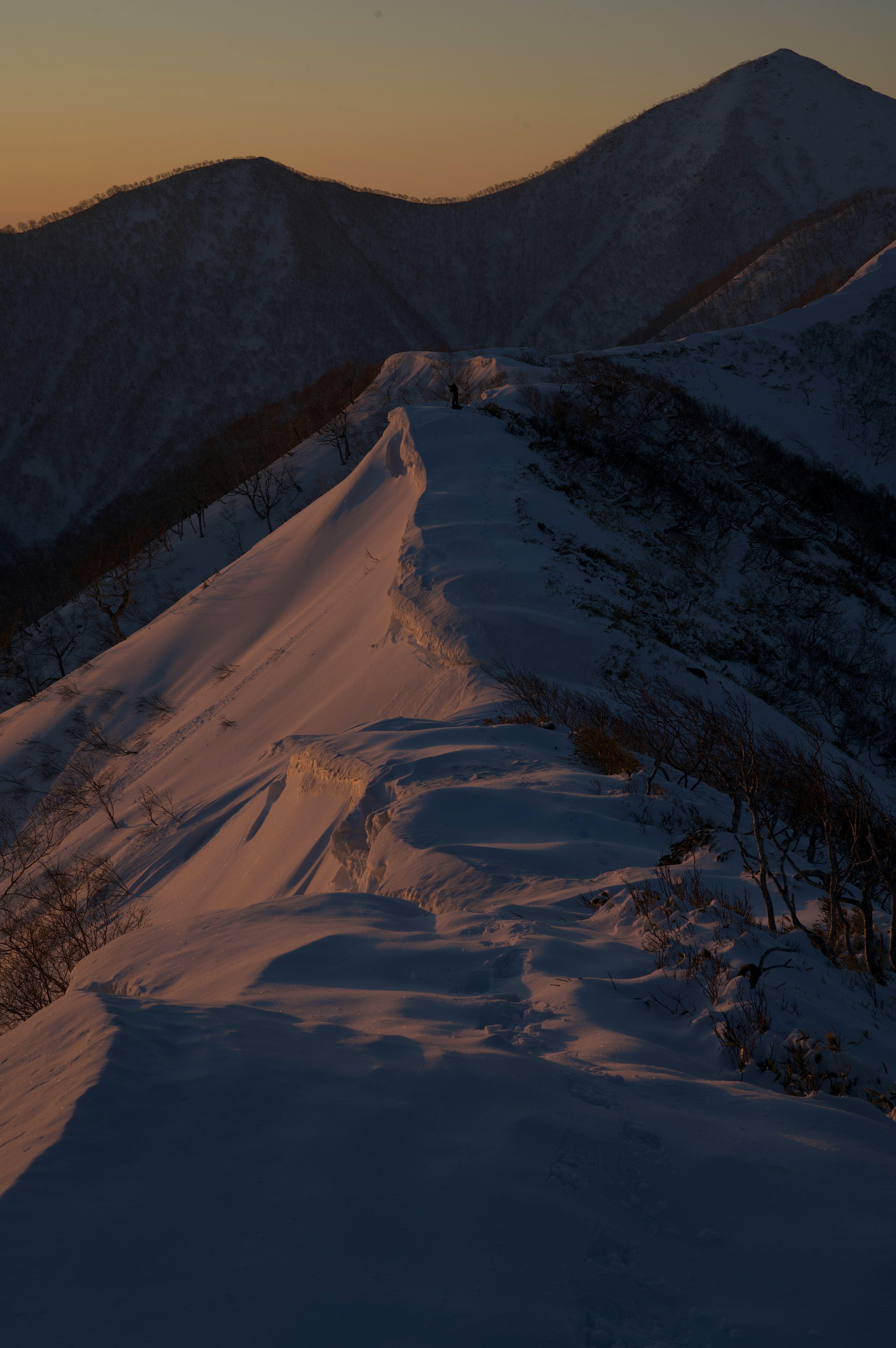 Cresta montuosa innevata al tramonto