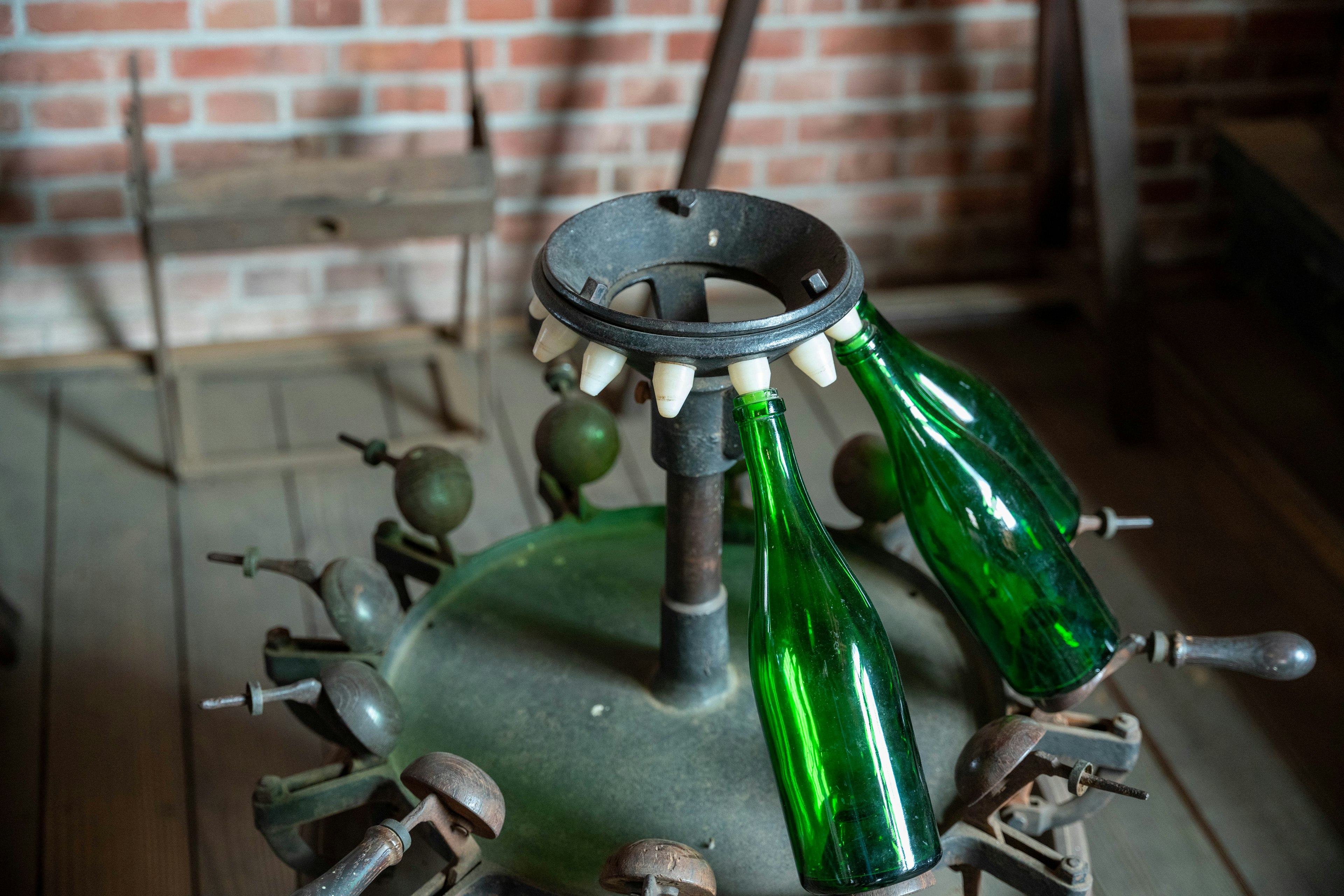 Parte de una antigua máquina de fabricación de vidrio con botellas verdes