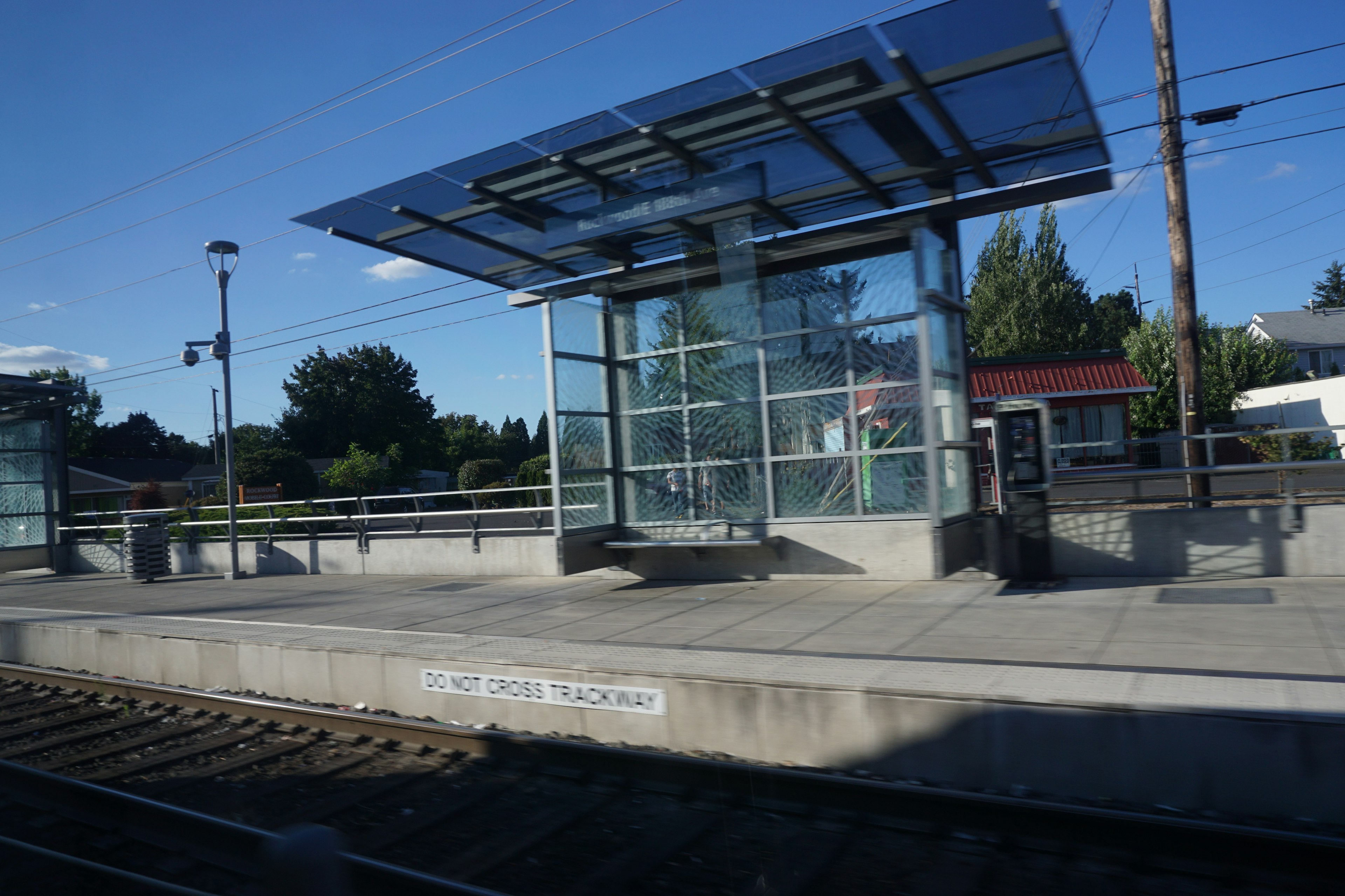 Train station platform with a glass shelter and clear skies