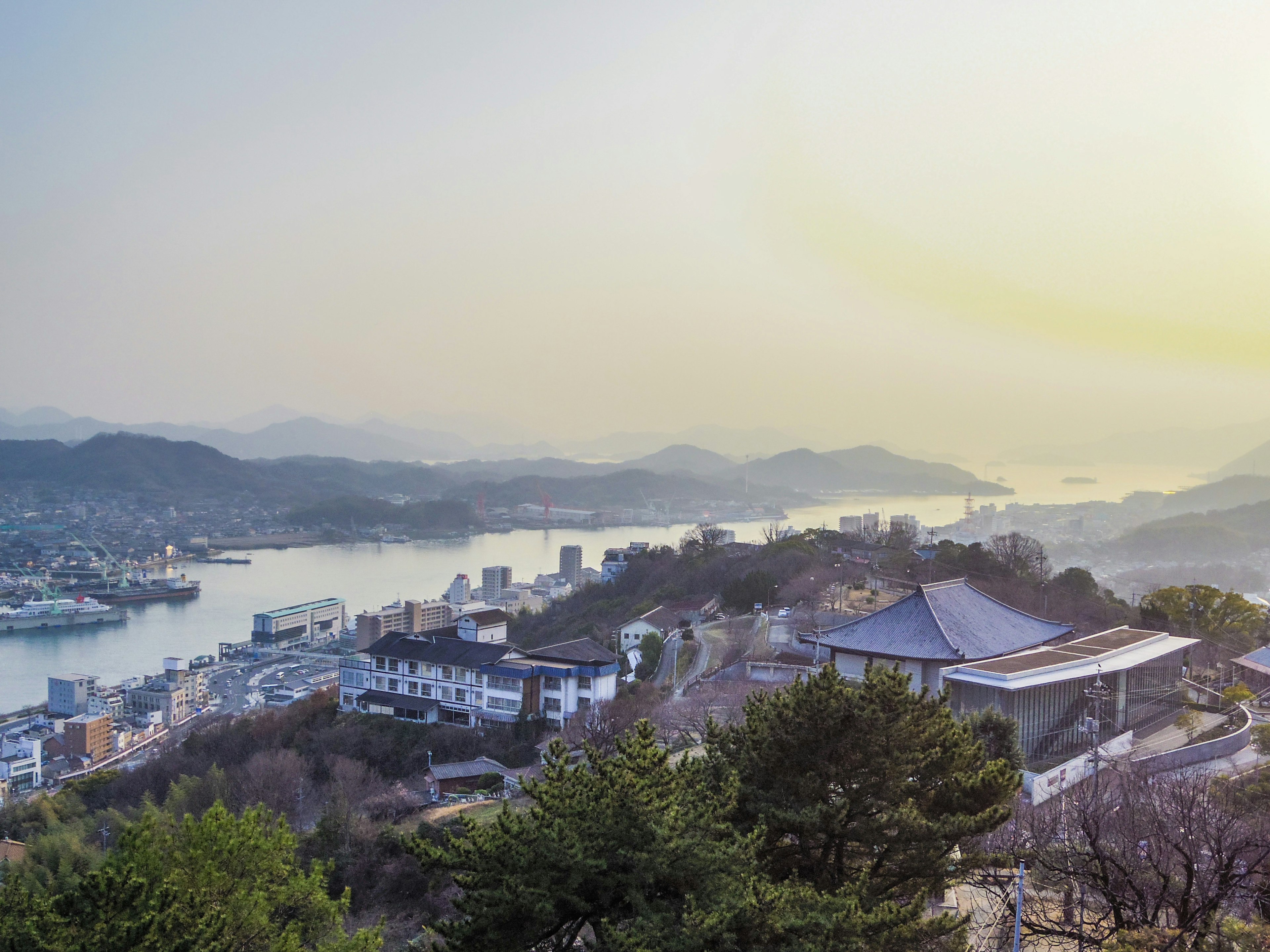 Scenic view of a tranquil town with mountains and river in the background