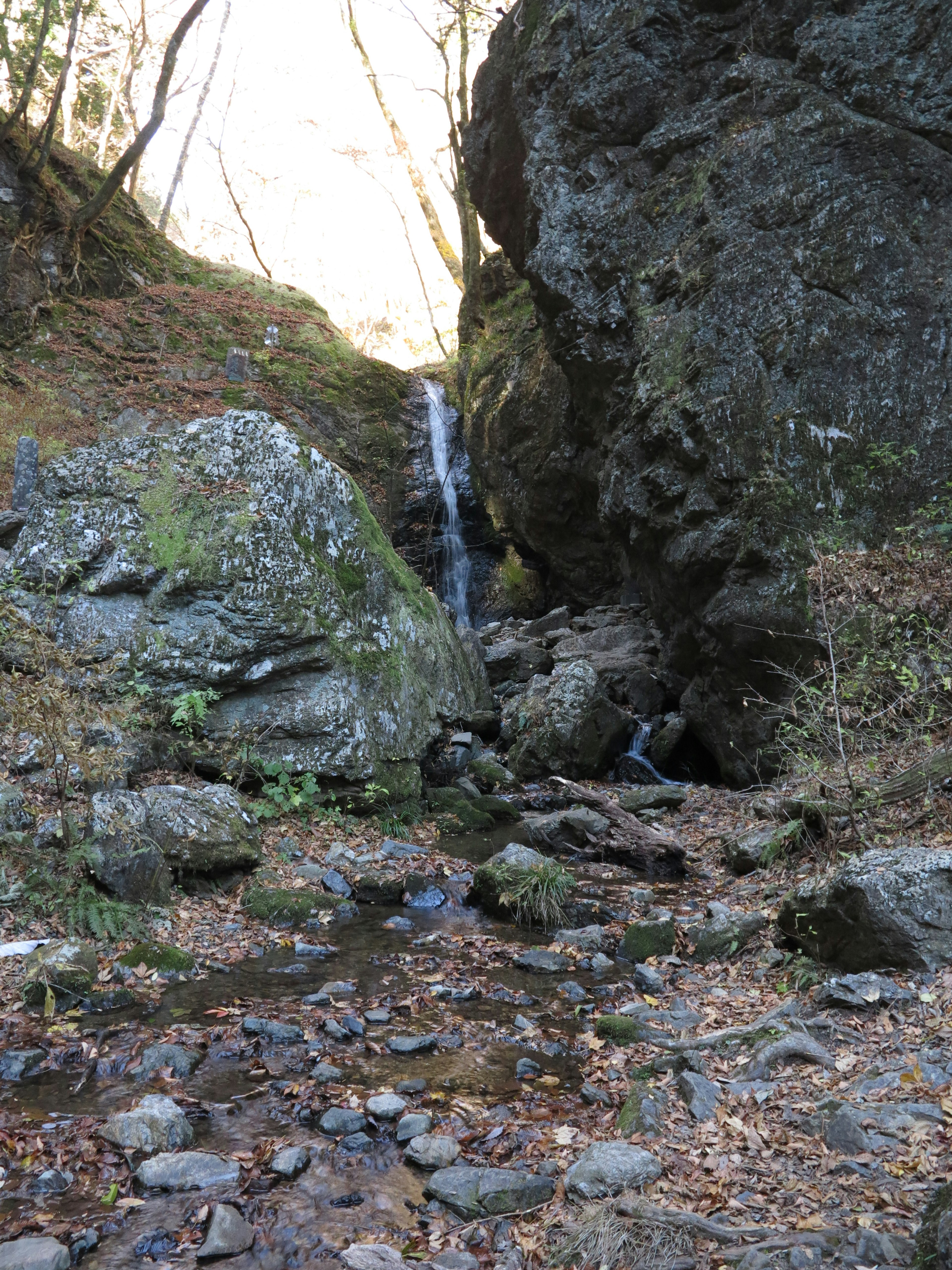 Ein kleiner Wasserfall umgeben von Felsen in einer Schlucht