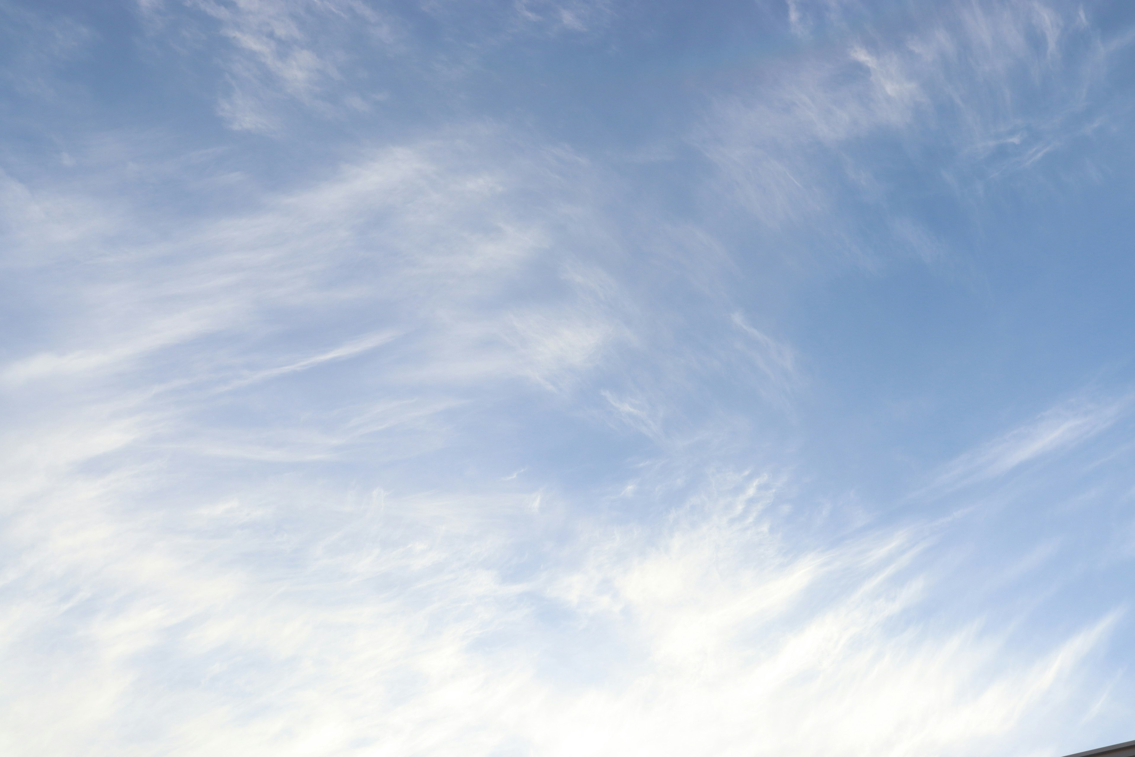 Un ciel bleu clair avec des nuages blancs flous