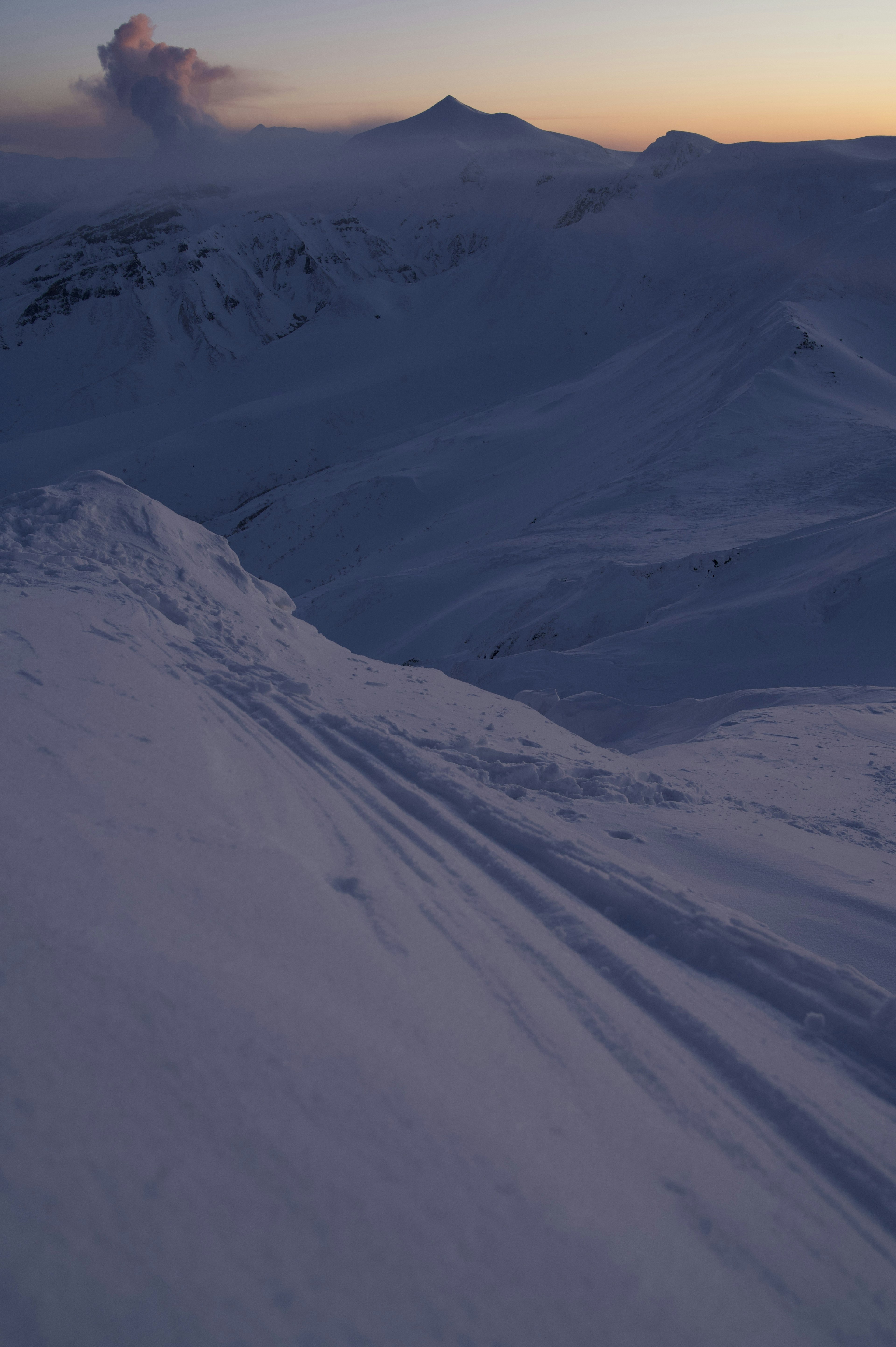 Snow-covered mountain landscape with sunset sky