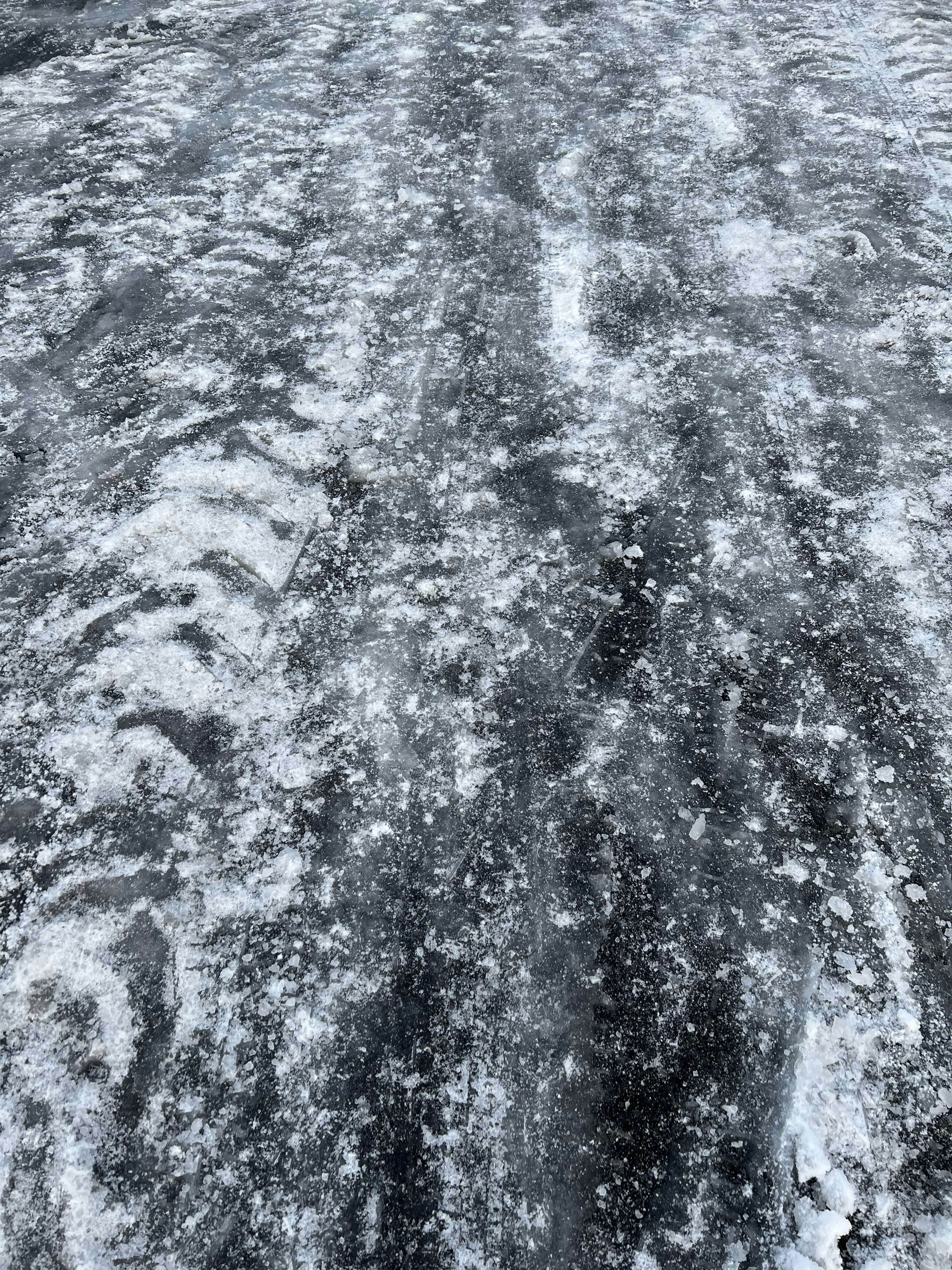 Gefrorene Straße mit Schneespuren und eisiger Textur