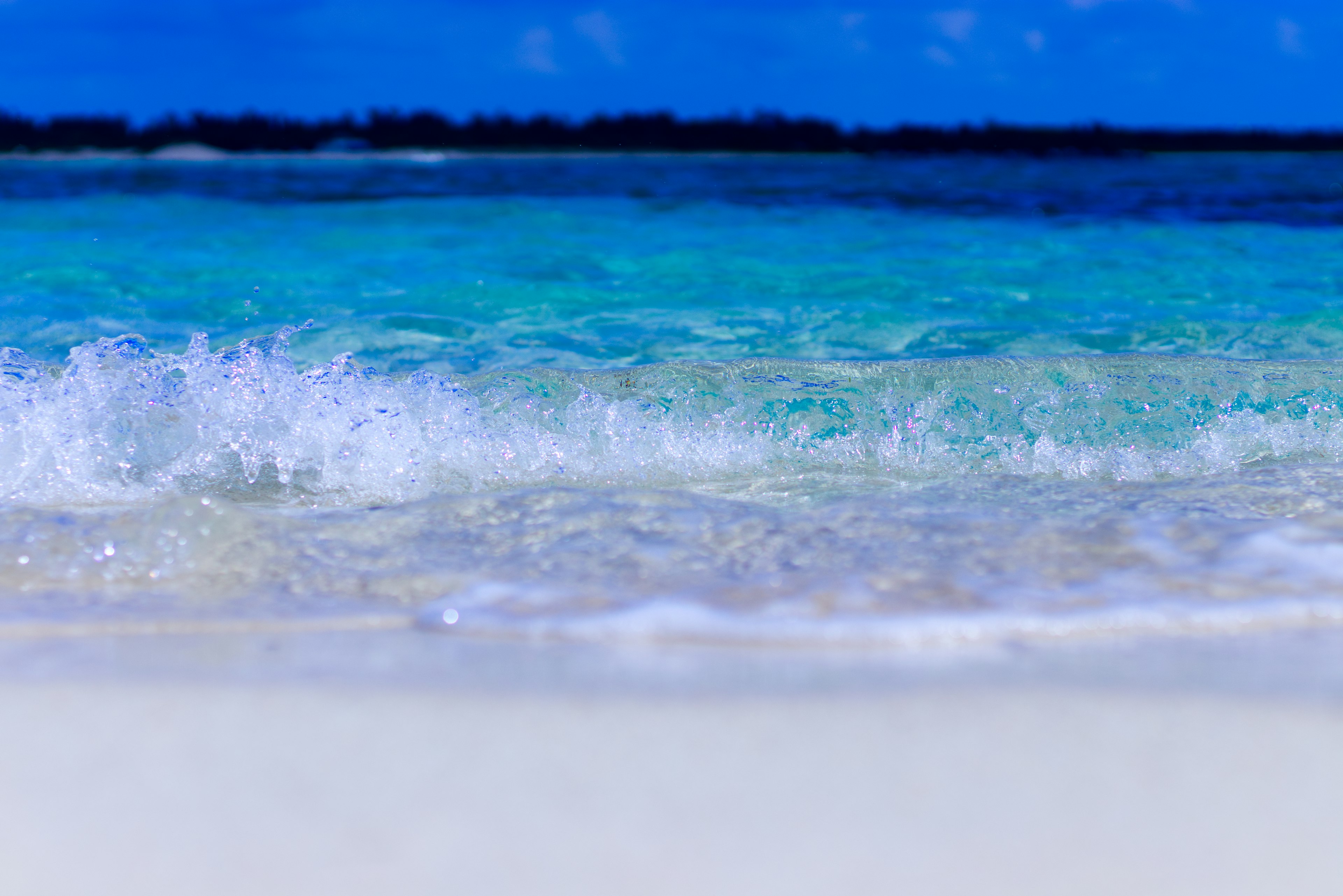 ทิวทัศน์สวยงามของมหาสมุทรสีน้ำเงินและชายหาดทรายขาวพร้อมคลื่น