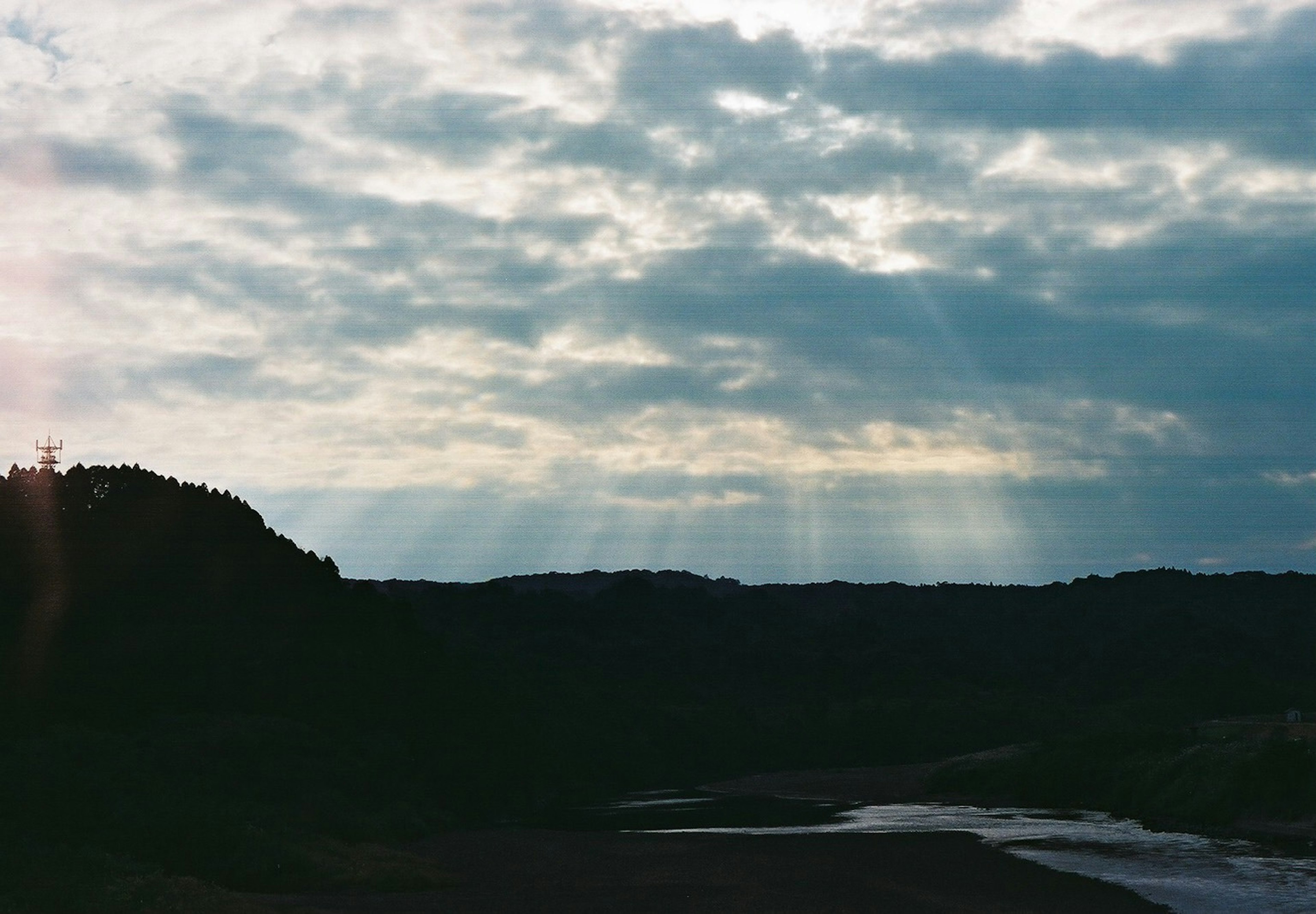 Bellissimo paesaggio con nuvole e raggi di luce nel cielo blu