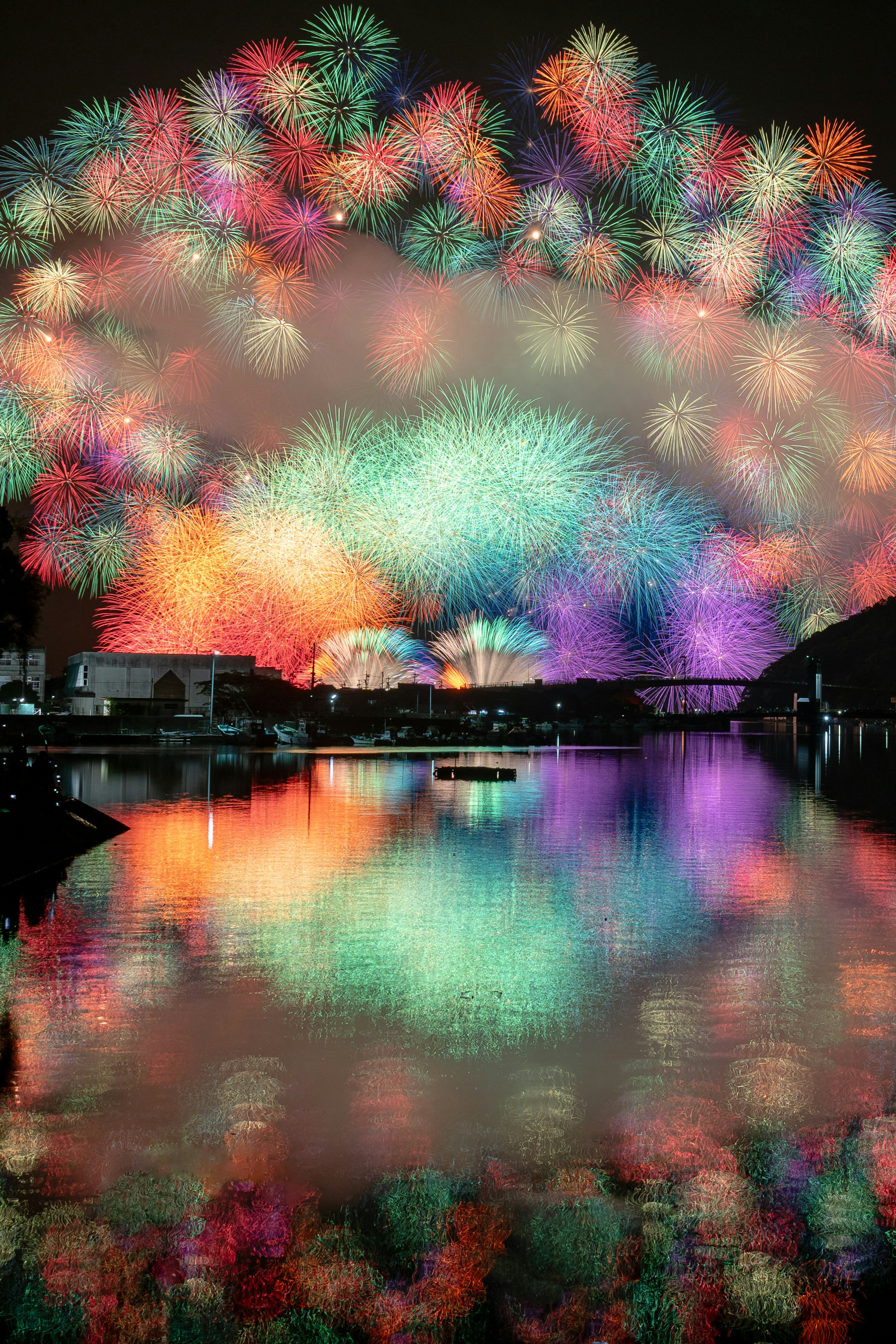 夜空中绽放的五彩烟花在水面上反射的美丽景象