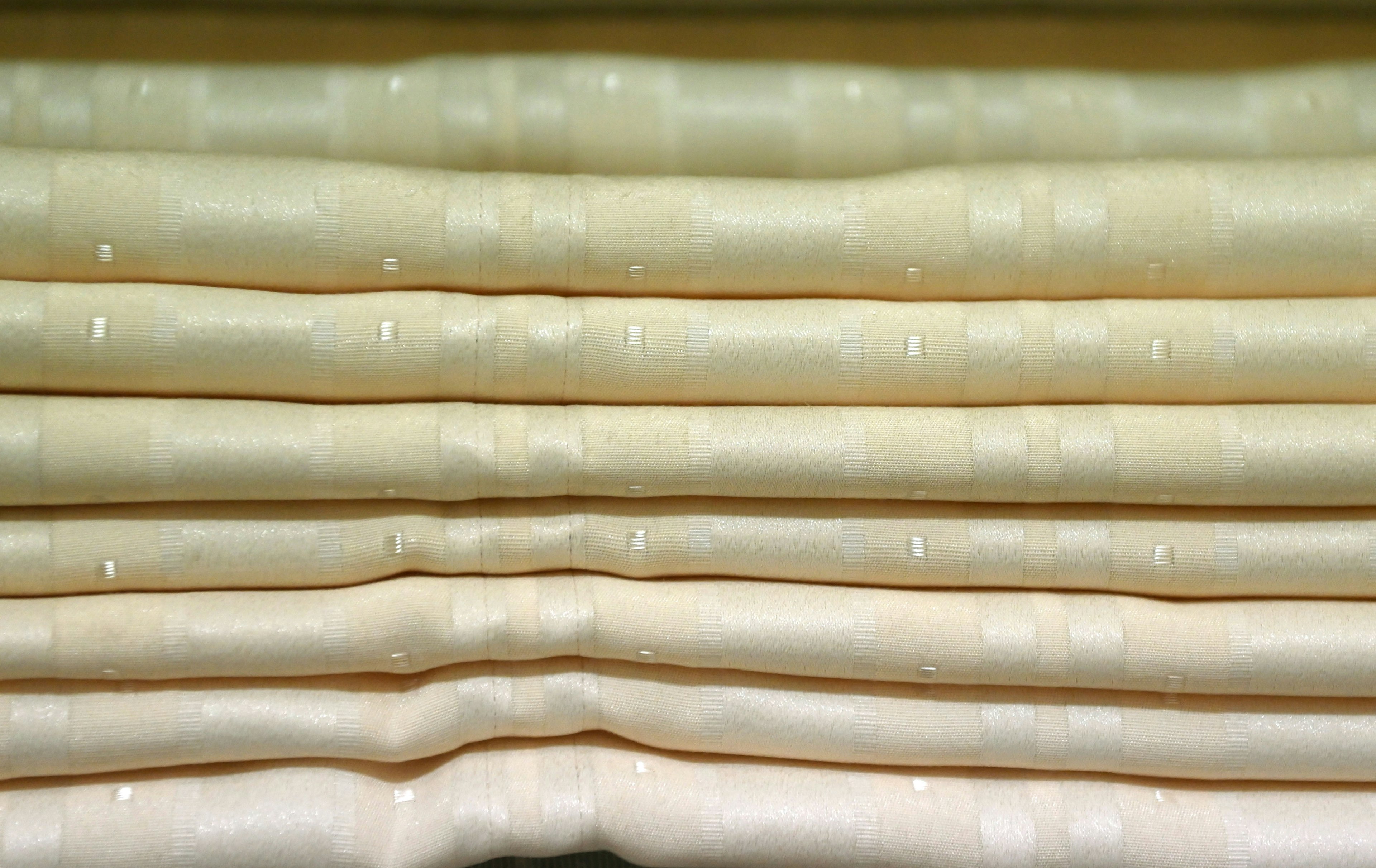 Detailed texture of stacked cream-colored fabrics